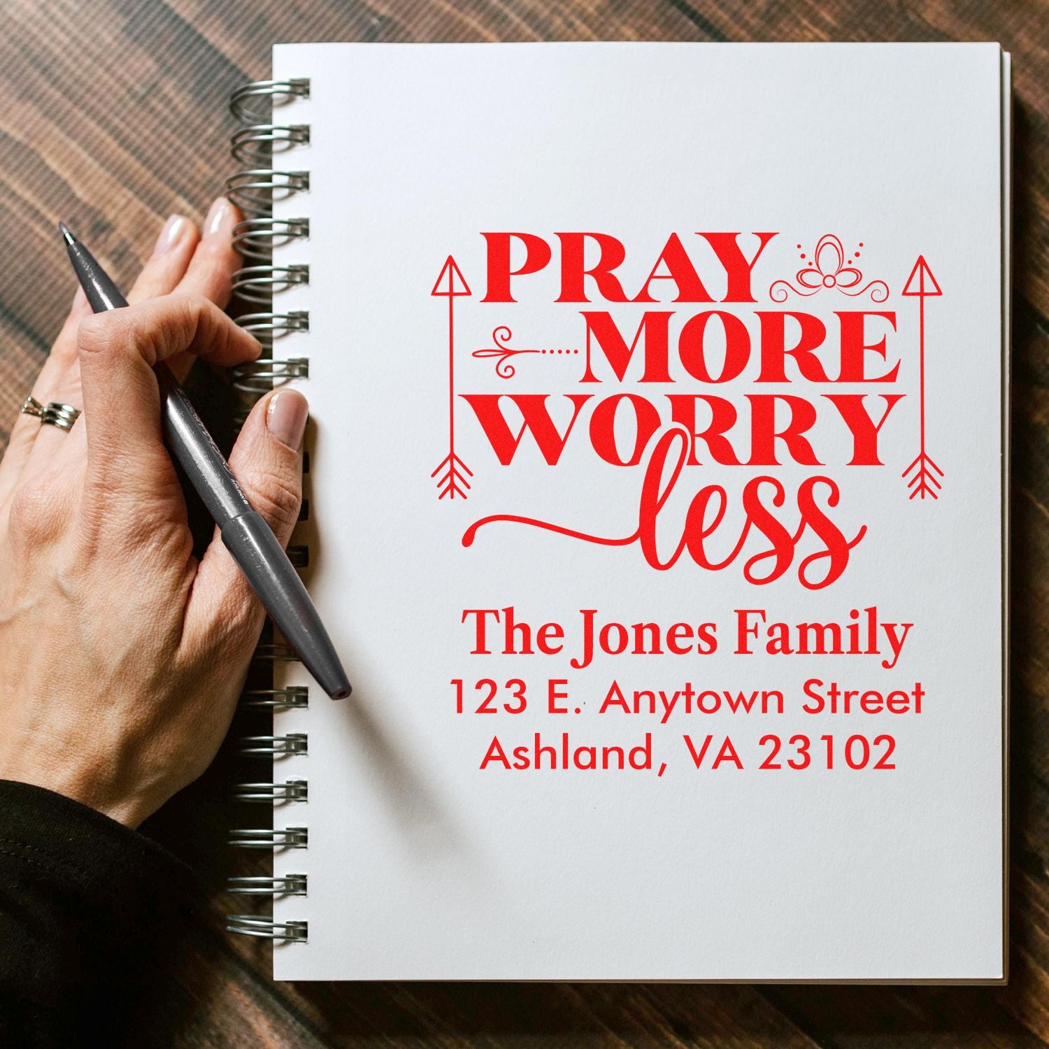 Custom return address rubber stamp with Pray More Worry Less and The Jones Family name on a notebook page.