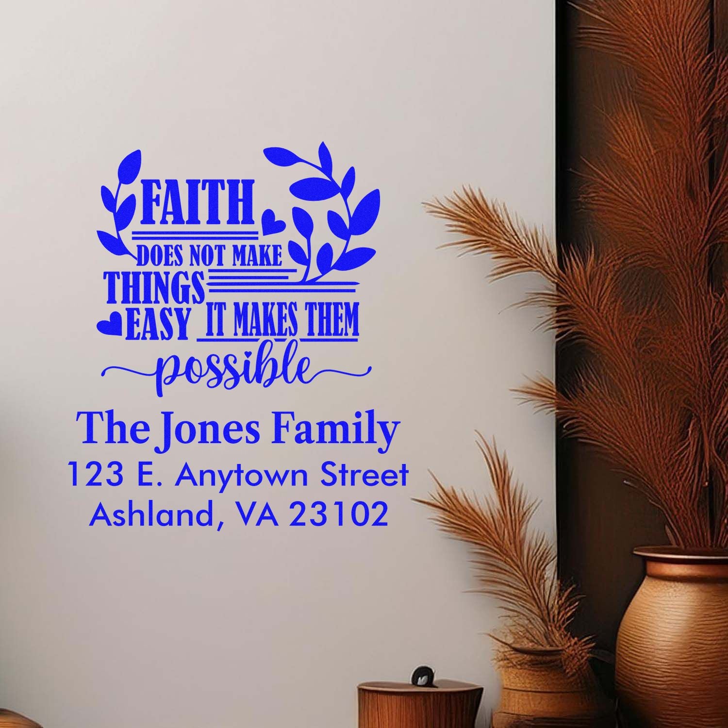 Personalized rubber stamp with faith quote, family name, and address in blue decorative lettering and leaf wreath.