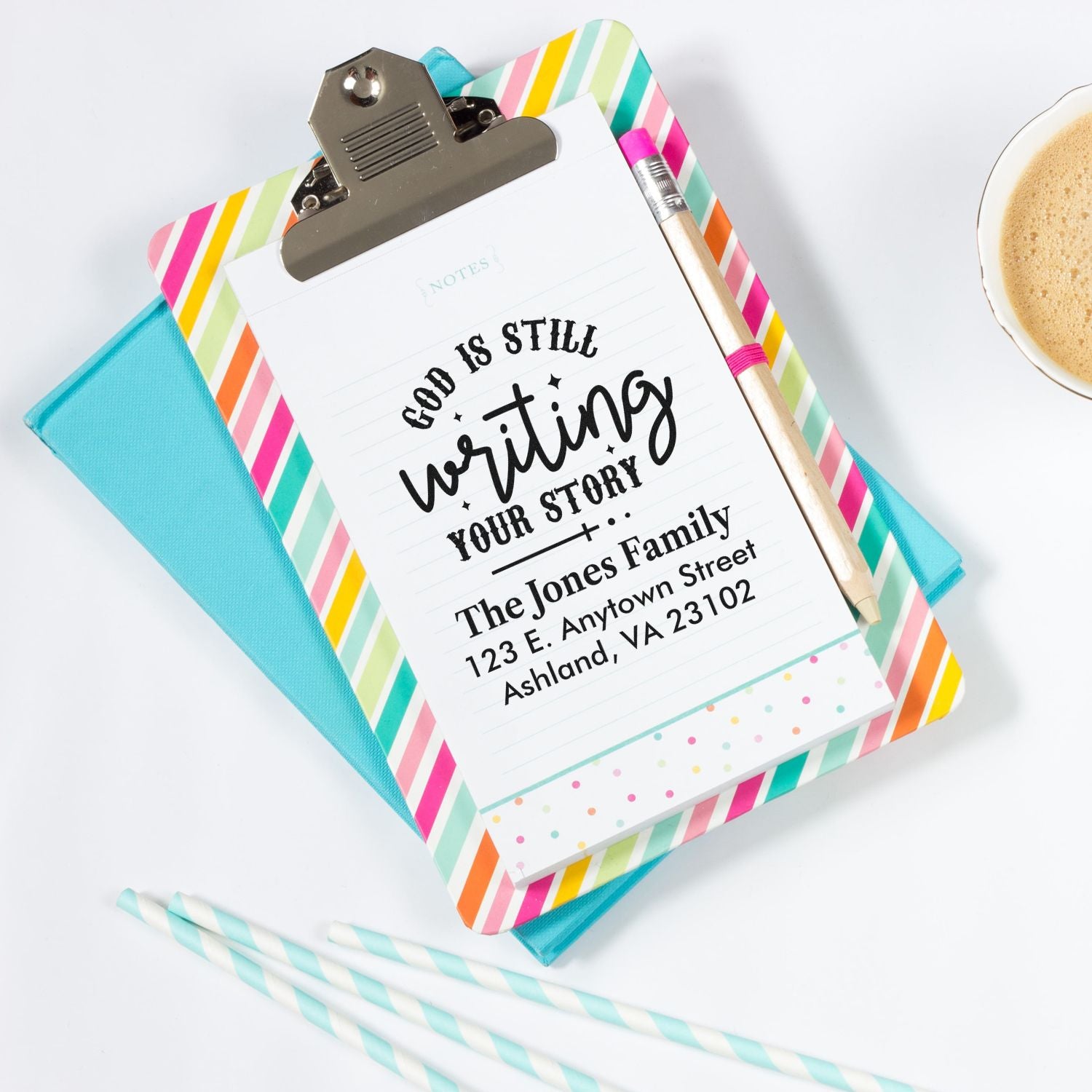 Personalized rubber stamp with God is still writing your story and custom return address on colorful clipboard.