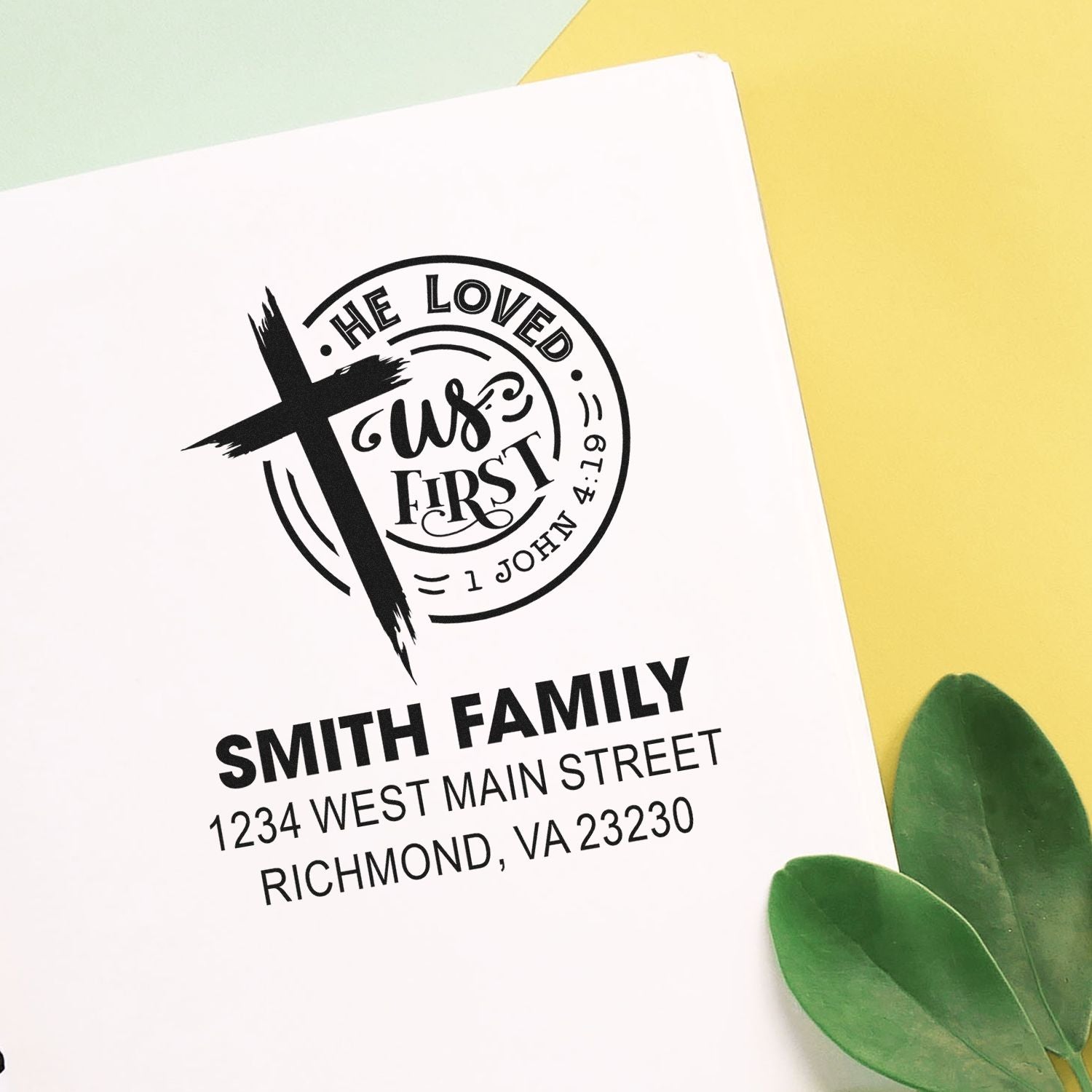 Custom Christian family return address rubber stamp with cross, He loved us first Bible verse, Smith Family name, and address.