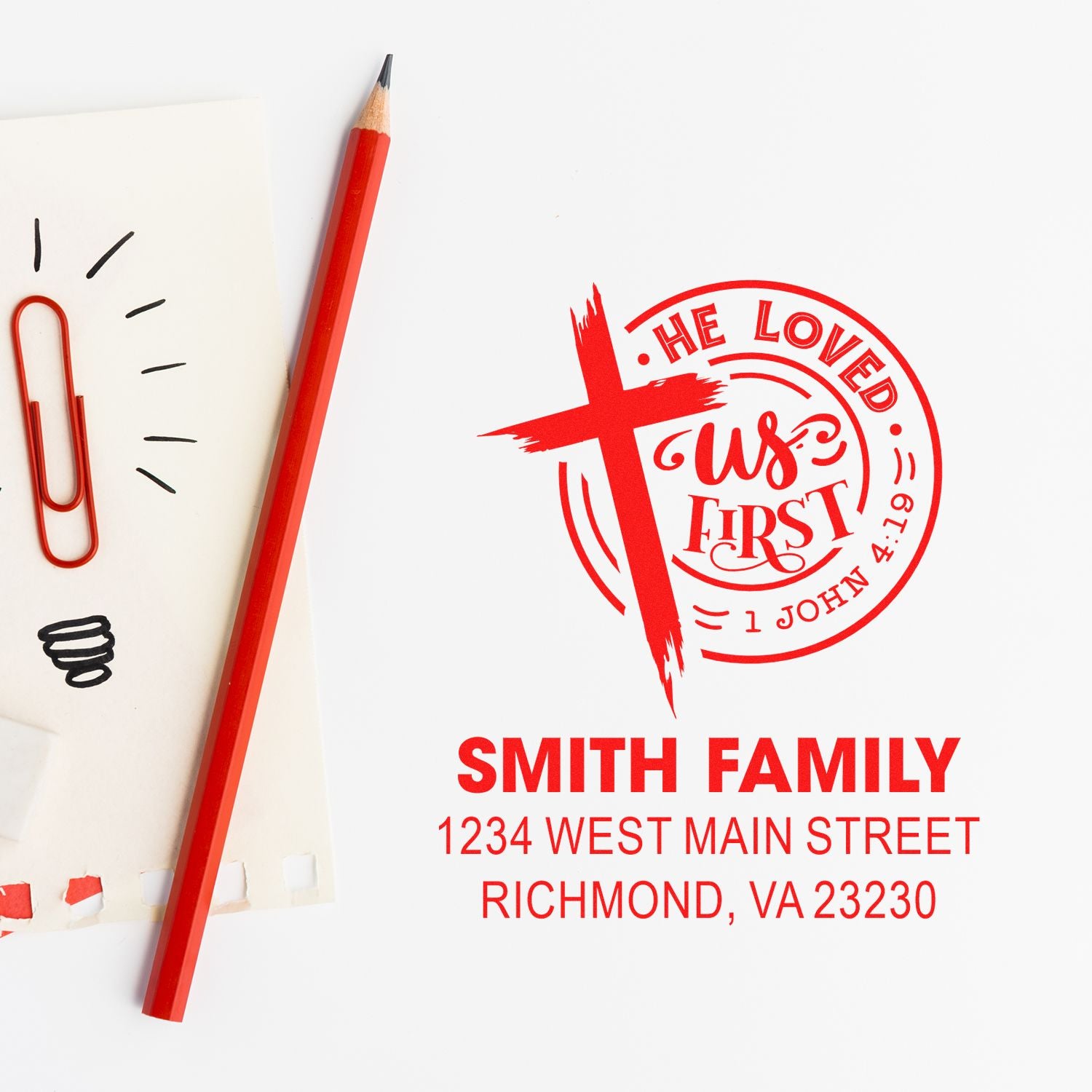 Custom return address rubber stamp with cross and He Loved Us First design for Smith family envelopes and stationery.