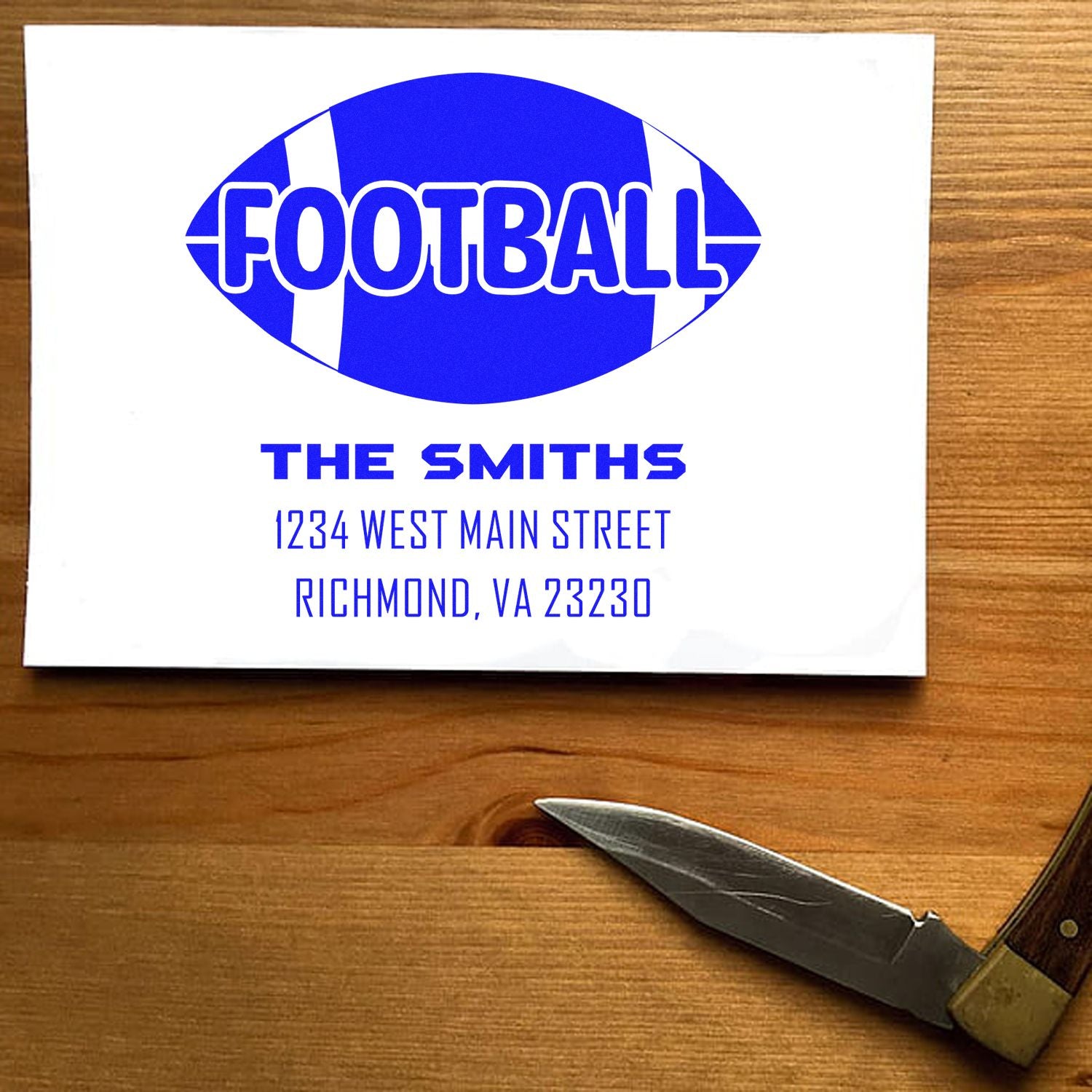 Personalized football return address rubber stamp design with family name and address, shown on a sample card.