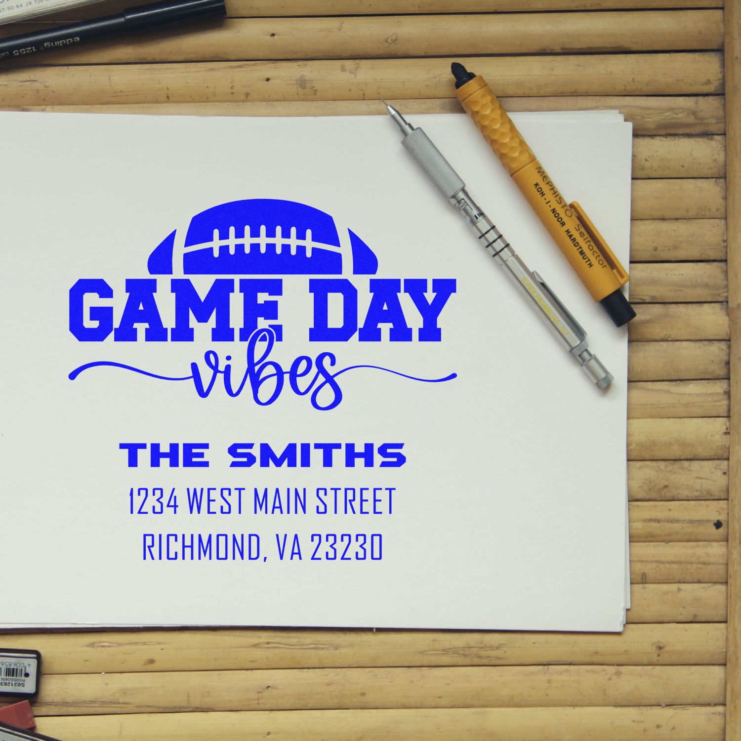 Custom rubber stamp design proof with Game Day Vibes football graphic, family name, and address