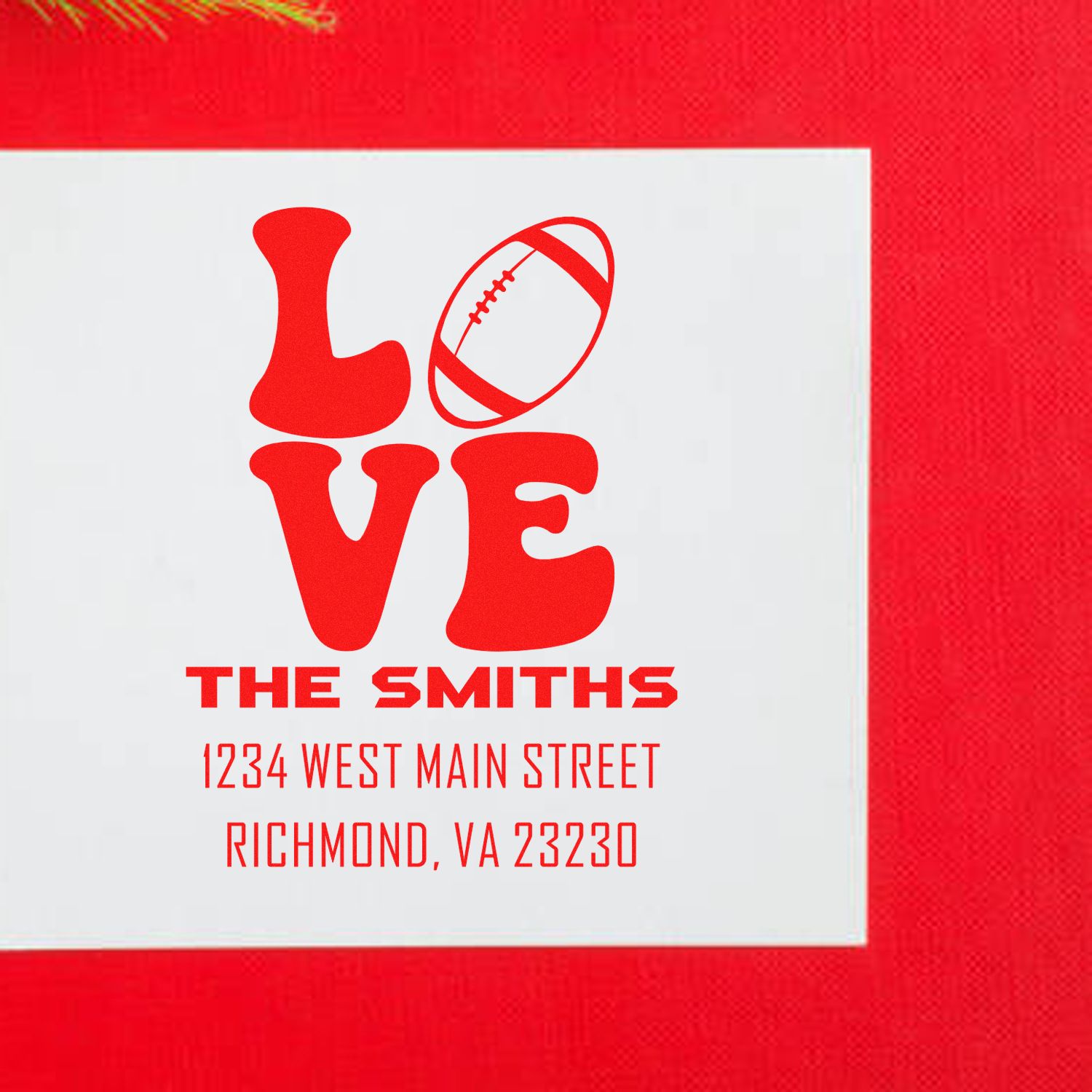 Custom return address rubber stamp with football LOVE design, family name, and address.