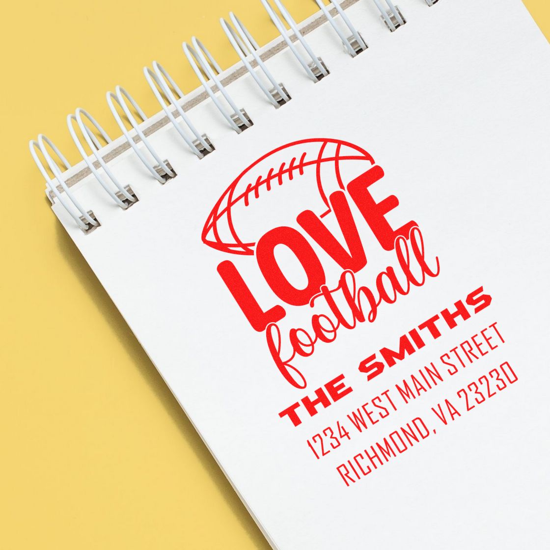 Custom football love rubber stamp with family name and address on a notebook mockup