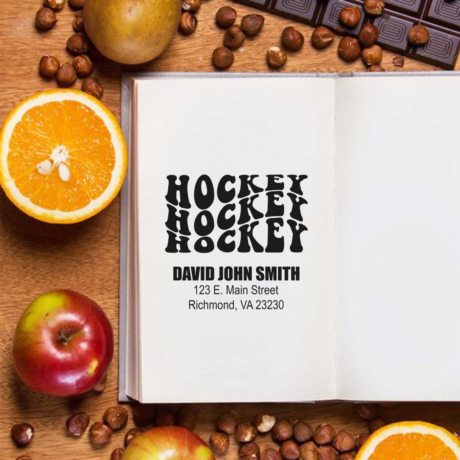 Personalized hockey rubber stamp with name and address imprint on an open book, perfect for custom sports stationery.