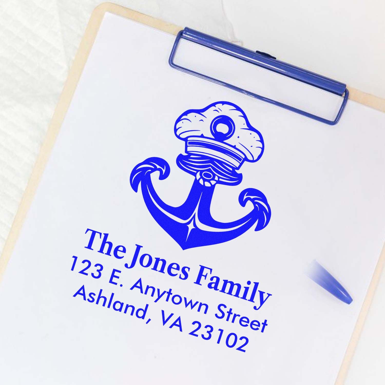 Custom rubber stamp with anchor design and family address on clipboard
