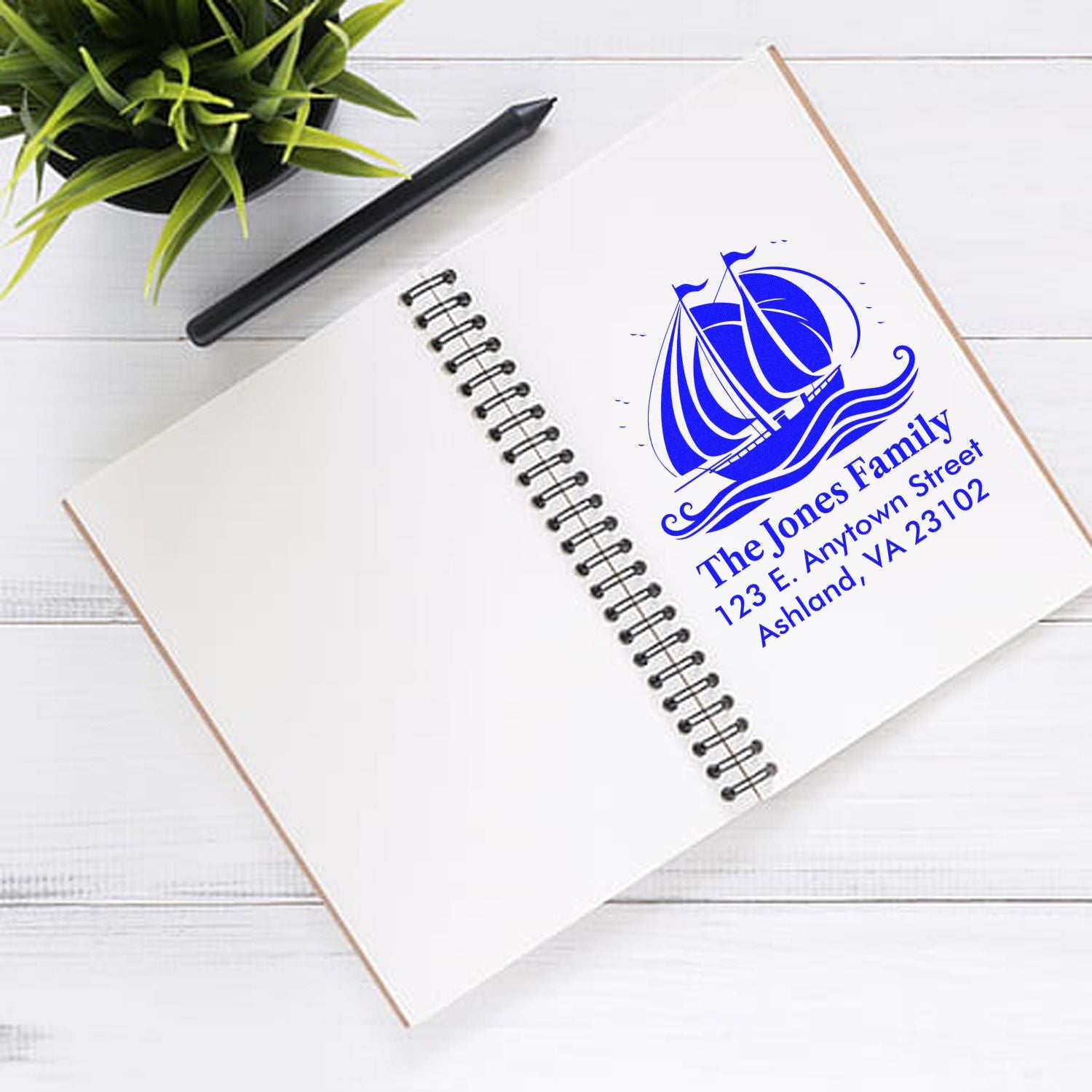 Custom family address rubber stamp imprint with sailboat logo on notebook page