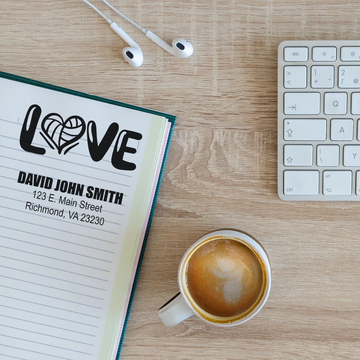 Personalized rubber stamp impression on notebook, featuring LOVE design and address for custom stationery branding.