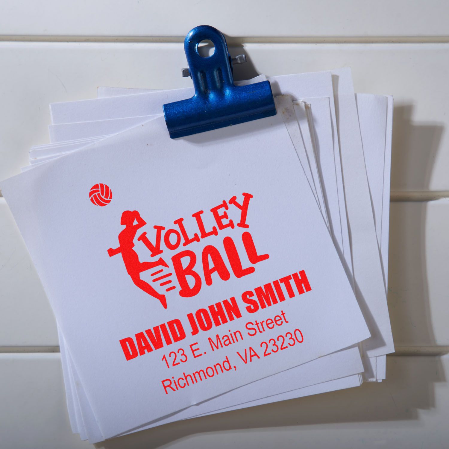 Custom volleyball return address rubber stamp on paper stack for branded team mailings.