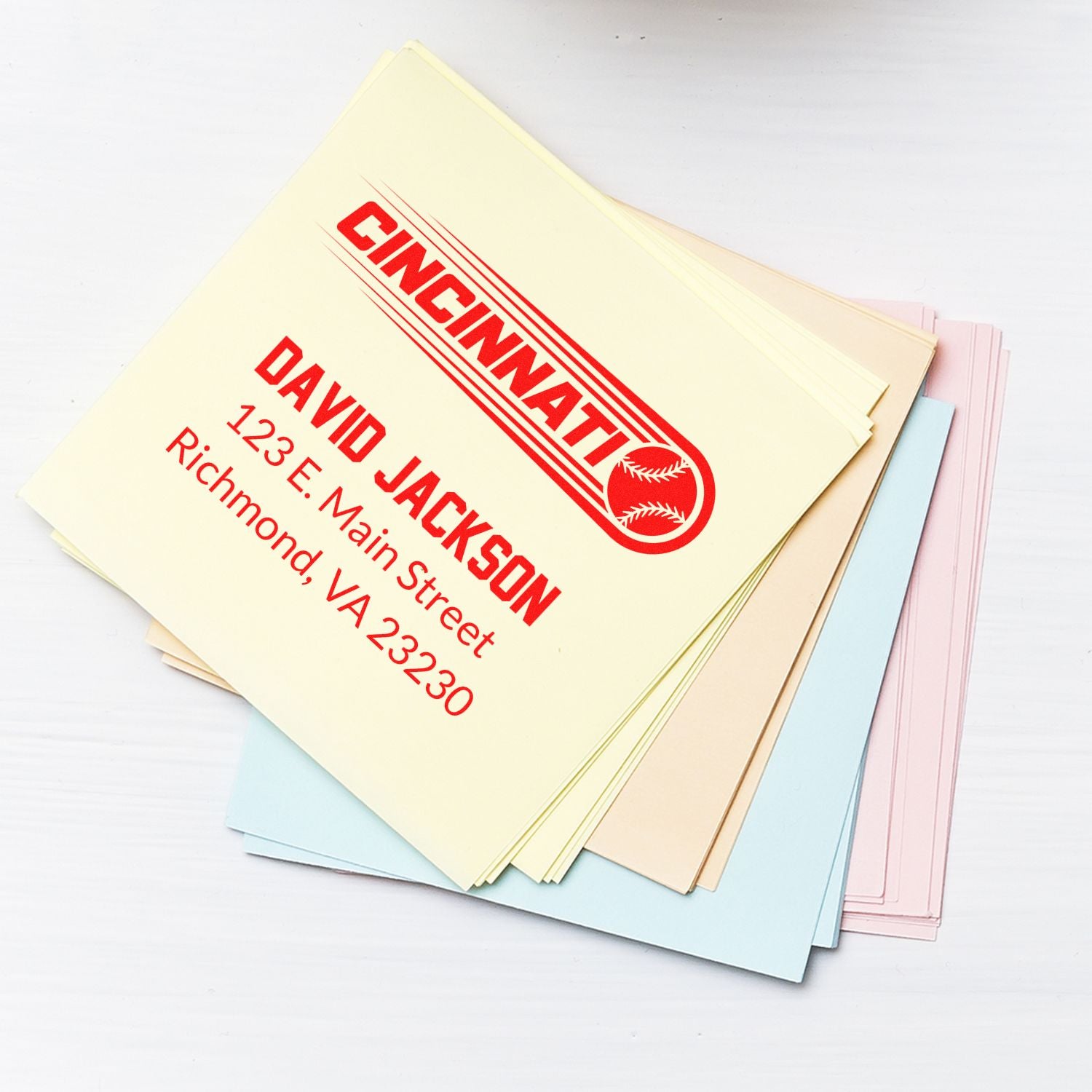 Custom rubber address stamp on stacked stationery, featuring Cincinnati David Jackson for business mailing and office use.