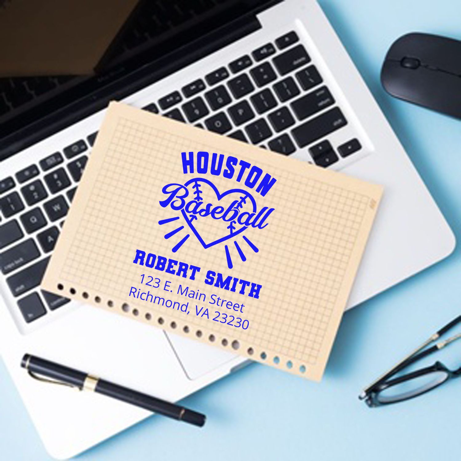 Custom rubber stamp impression for Houston Baseball, personalized with name and address, displayed on stationery beside a laptop.