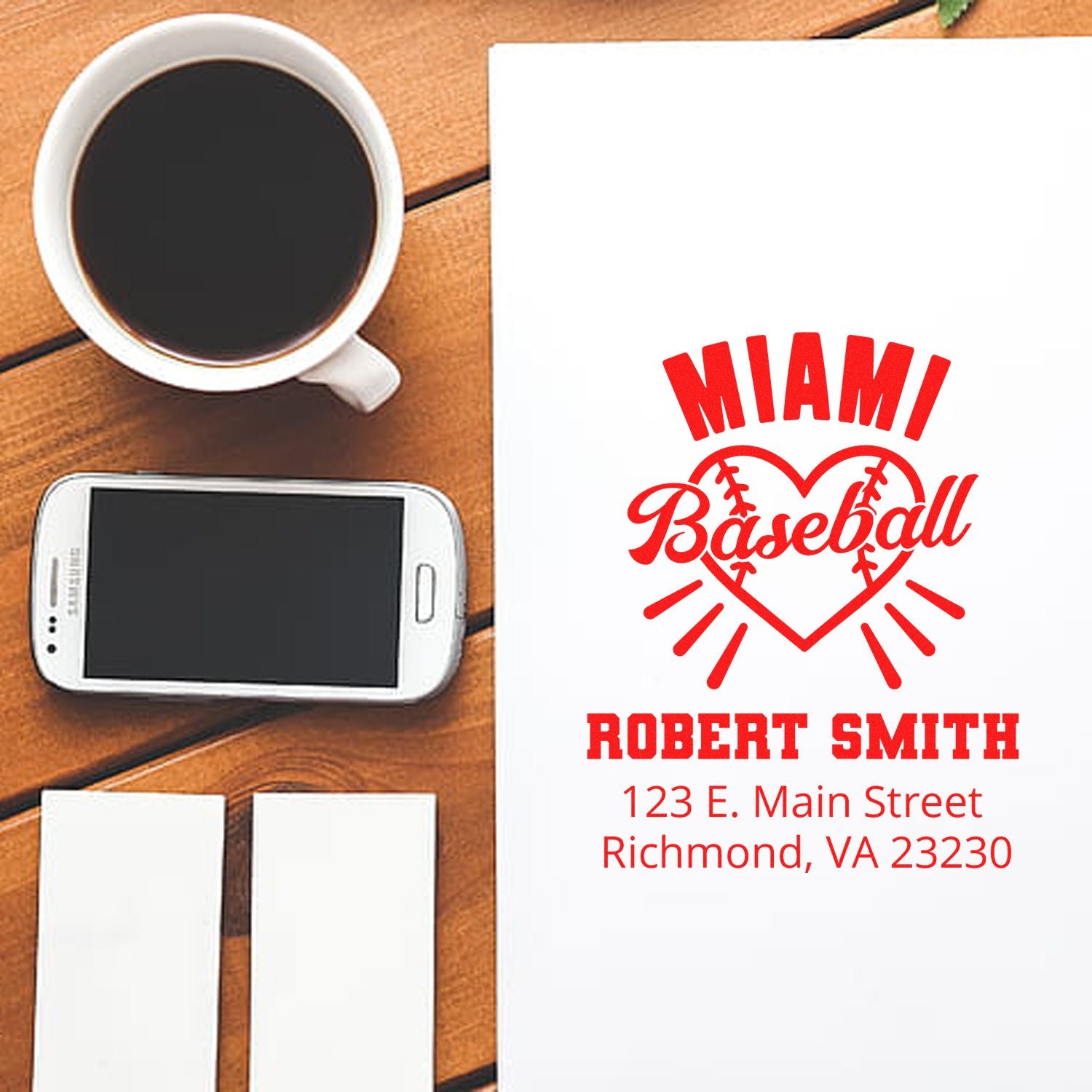 Custom Miami Baseball return address rubber stamp with name and address, shown on stationery beside coffee and phone.
