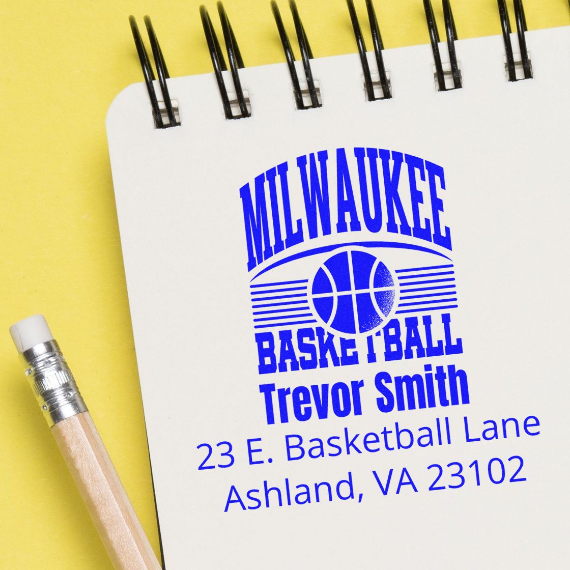 Custom Milwaukee Basketball address rubber stamp for Trevor Smith, Ashland, VA 23102, shown on a notebook.