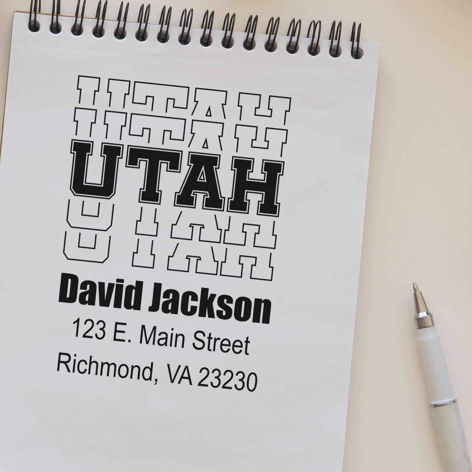 Custom Utah address rubber stamp proof with name and address layout on a spiral notepad.