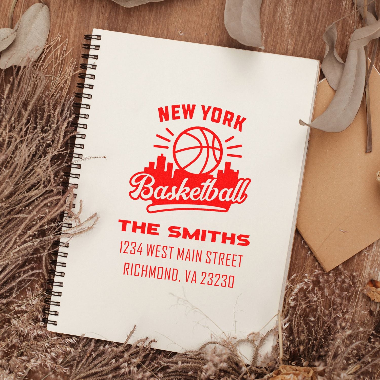 Personalized rubber stamp with New York basketball design, The Smiths name, and return address on notebook.