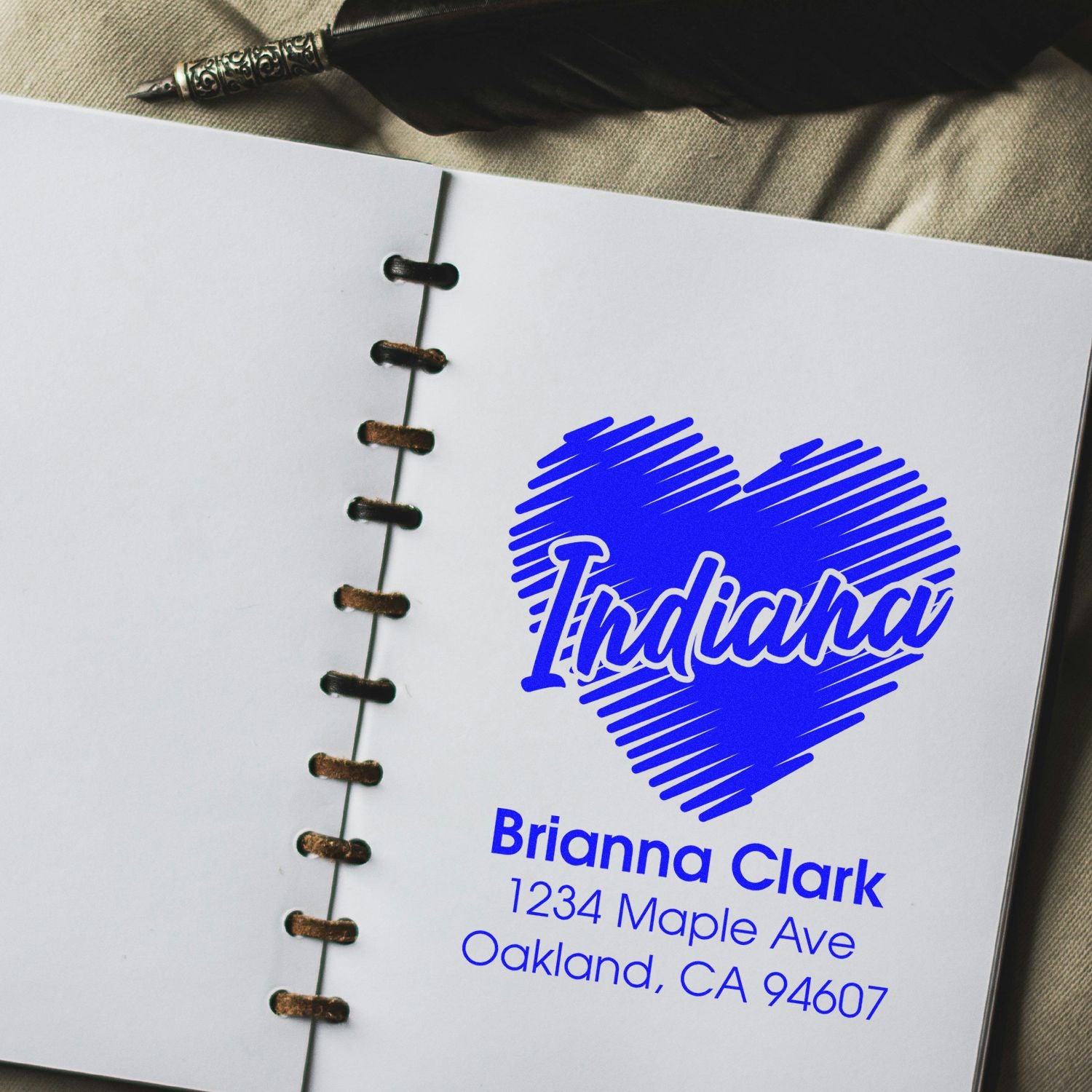 Custom rubber stamp design with Indiana heart and Brianna Clark return address on a notebook page.