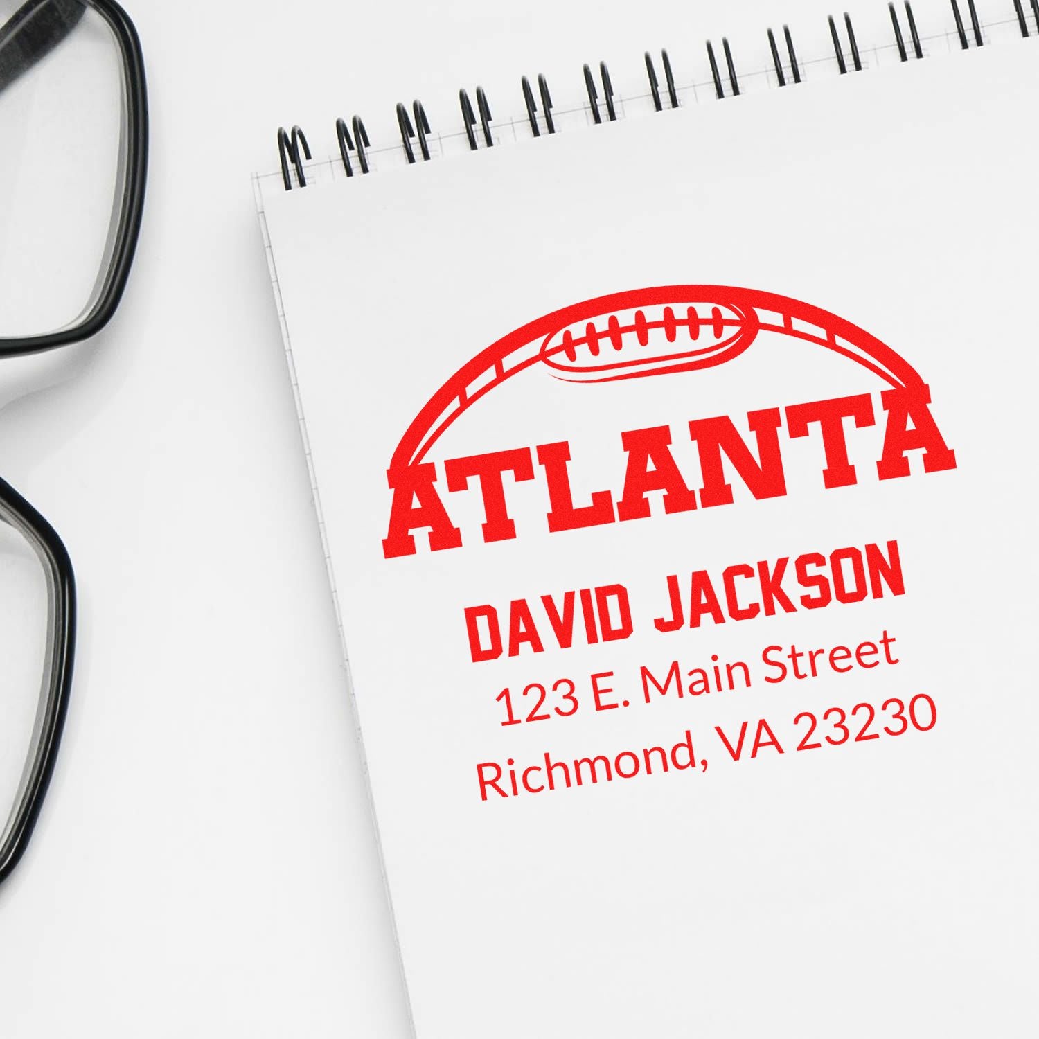Custom Atlanta rubber stamp with football design and address on notebook, ideal for personalized mailing and branding.