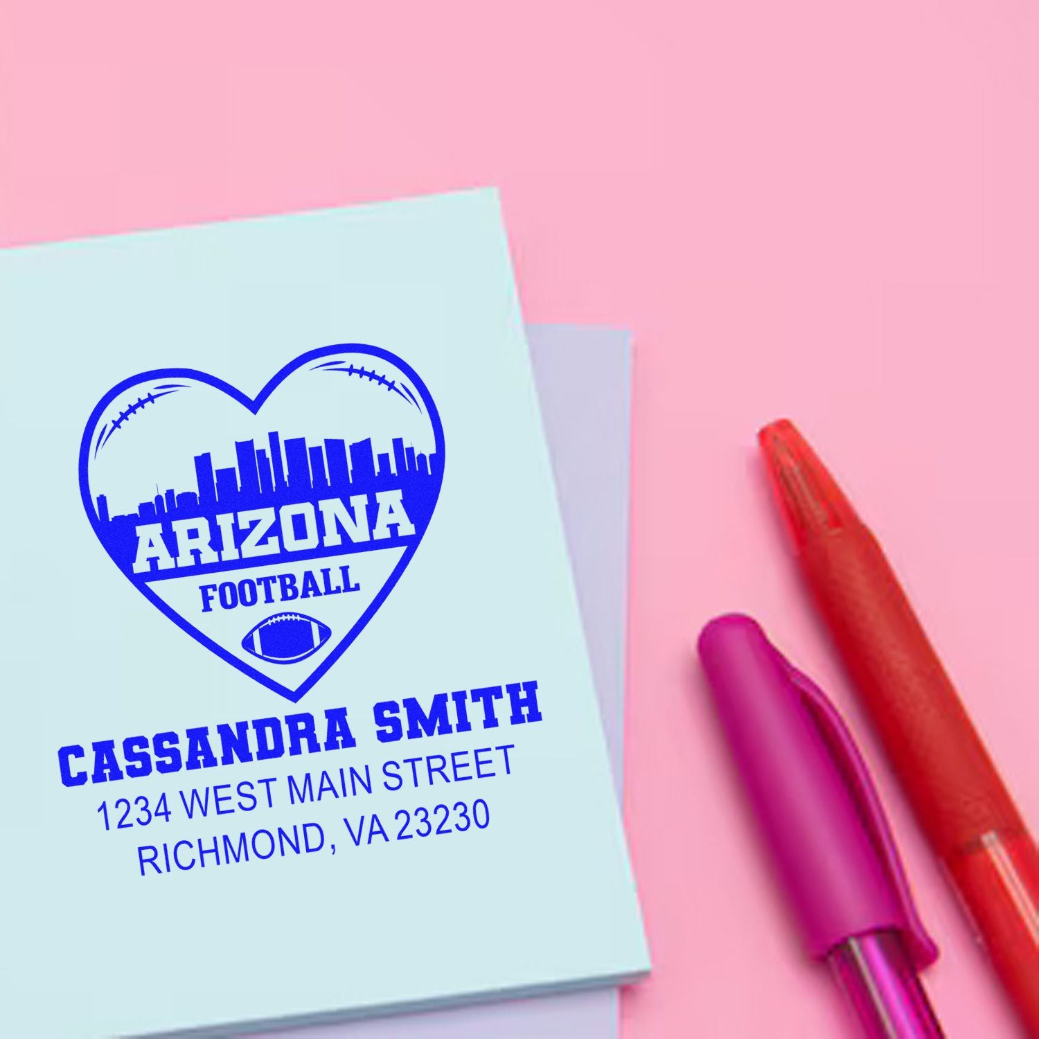 Custom Arizona football rubber stamp with heart skyline design, Cassandra Smith name, address, and pens on pink background.