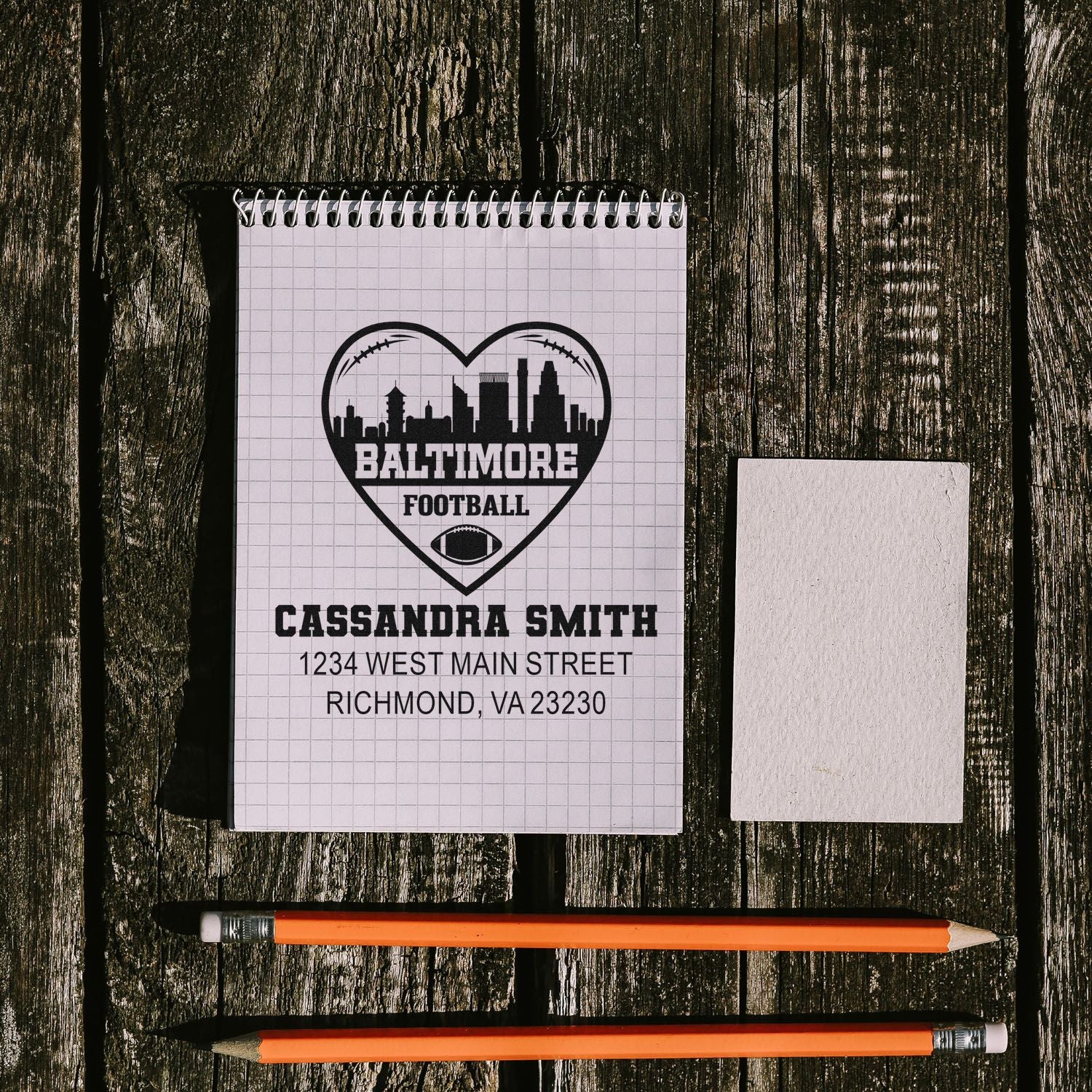 Custom rubber stamp mockup featuring Baltimore football heart logo, name, and address for personalized address stamping.