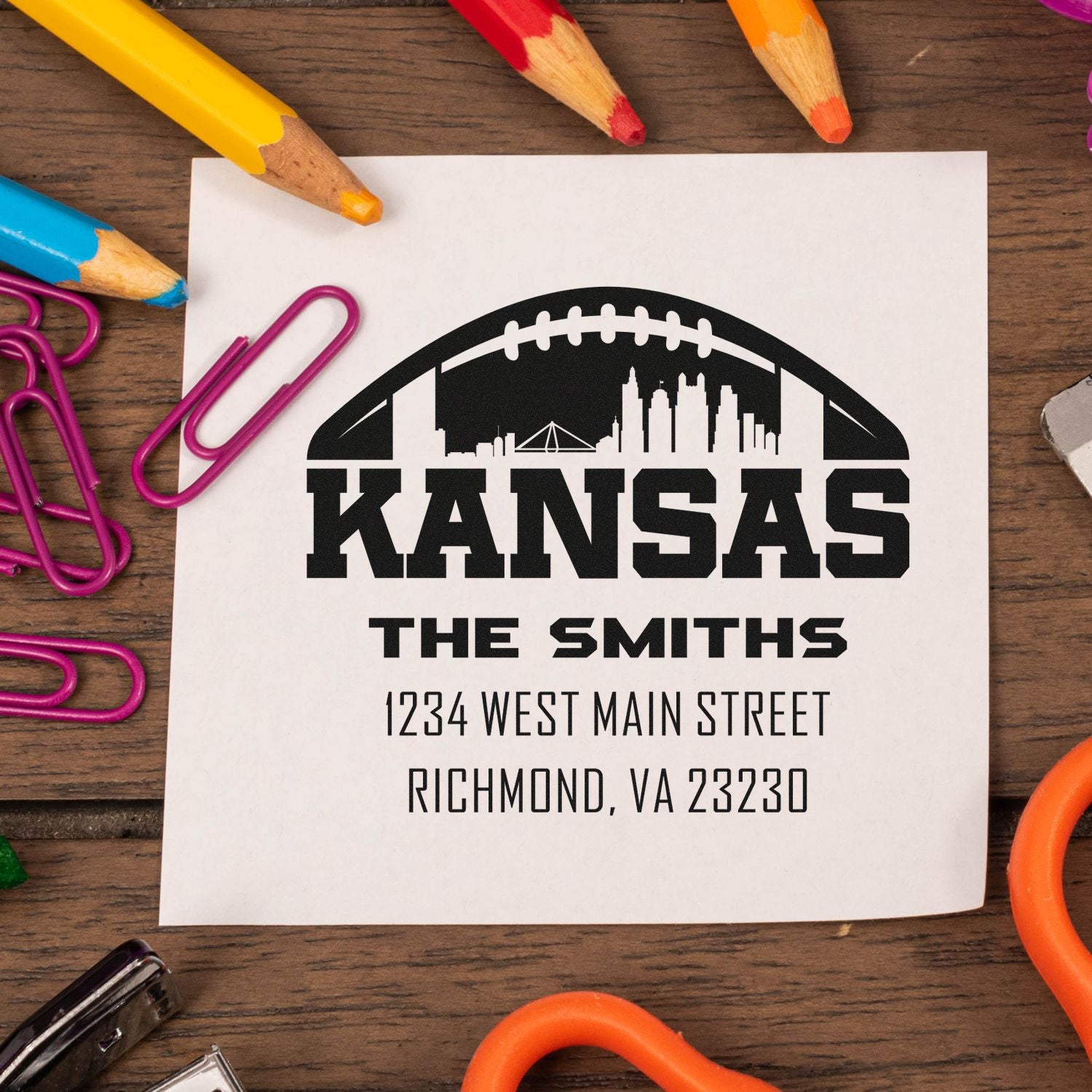 Personalized Kansas football return address rubber stamp with family name, street address, and city skyline.