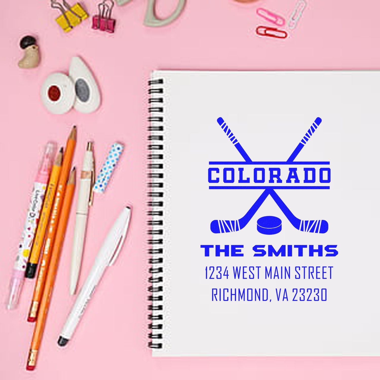 Custom Colorado hockey rubber stamp with family name and address, shown on a spiral notebook mockup.