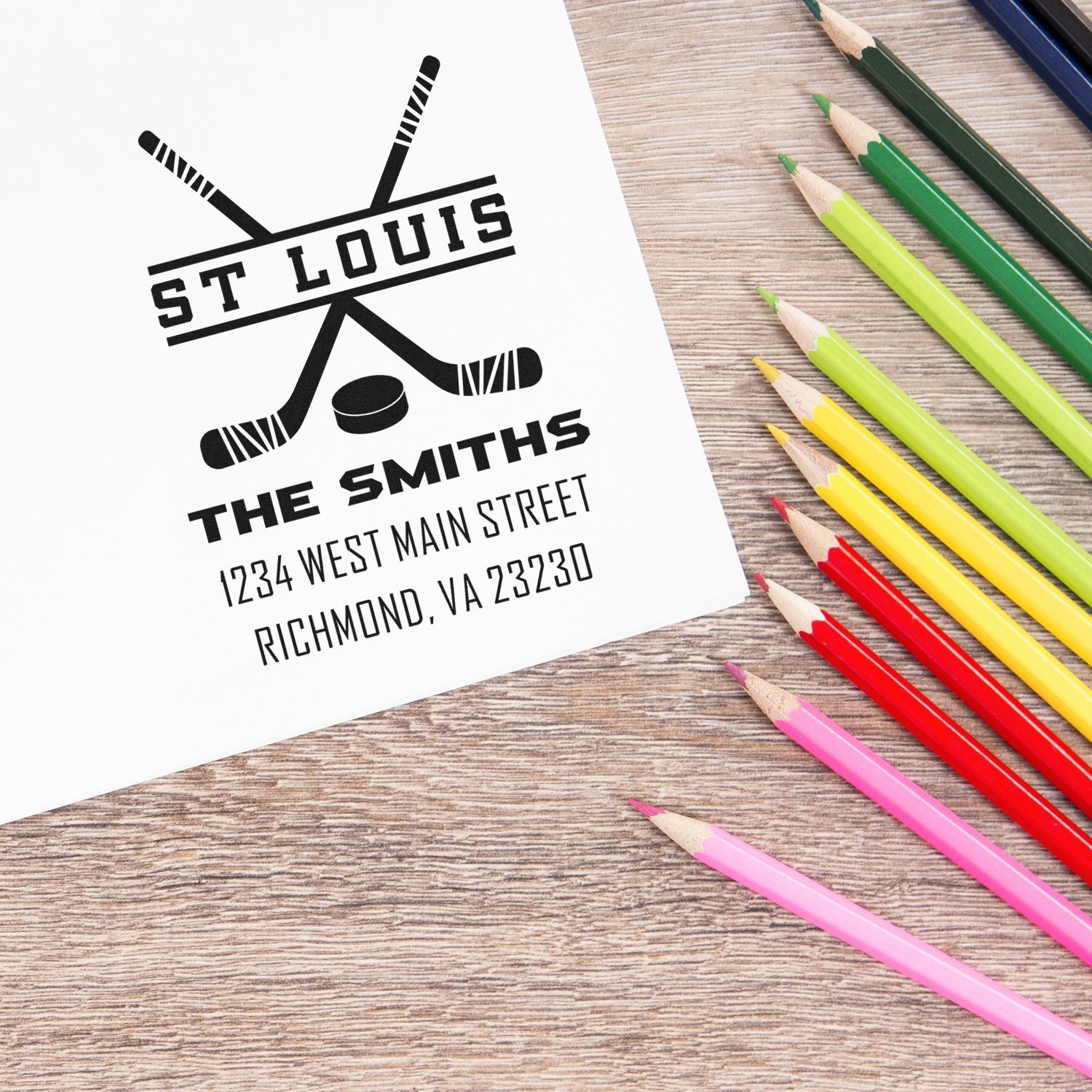 Custom hockey-themed rubber stamp with personalized St. Louis family name and return address on paper.