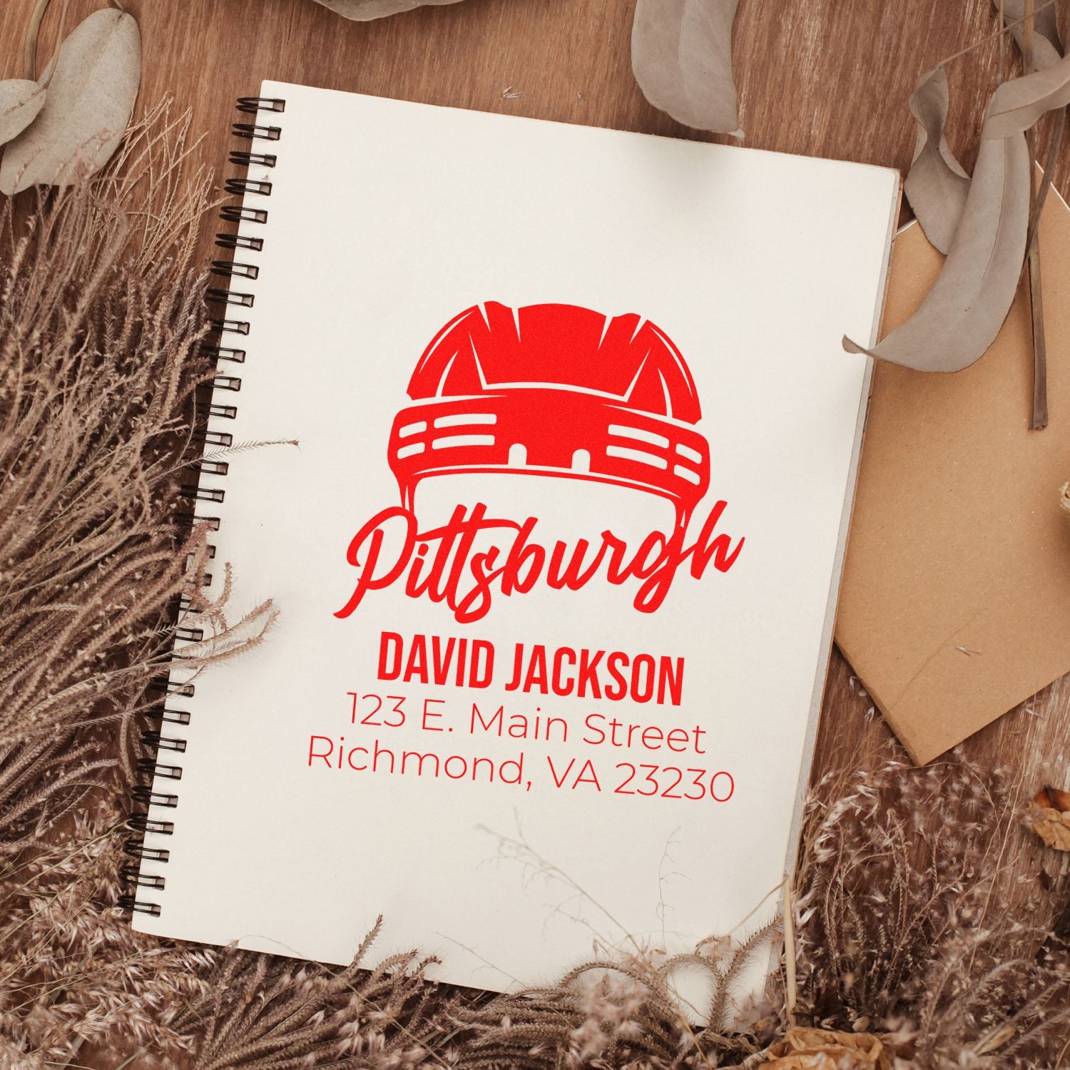Custom Pittsburgh return address rubber stamp mockup with name and address on a notebook.