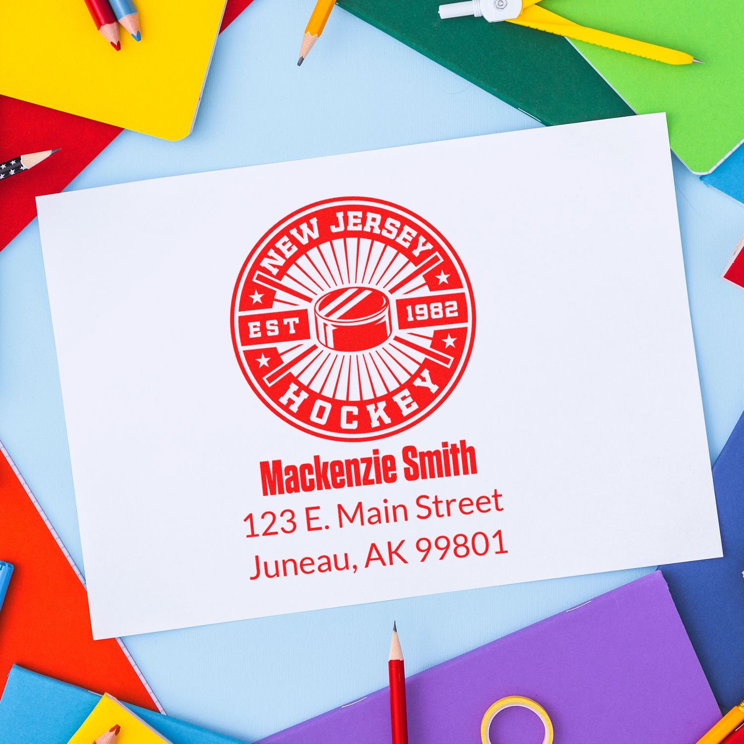 Custom rubber stamp for hockey branding with name and address, featuring a New Jersey Hockey logo on a printed card.