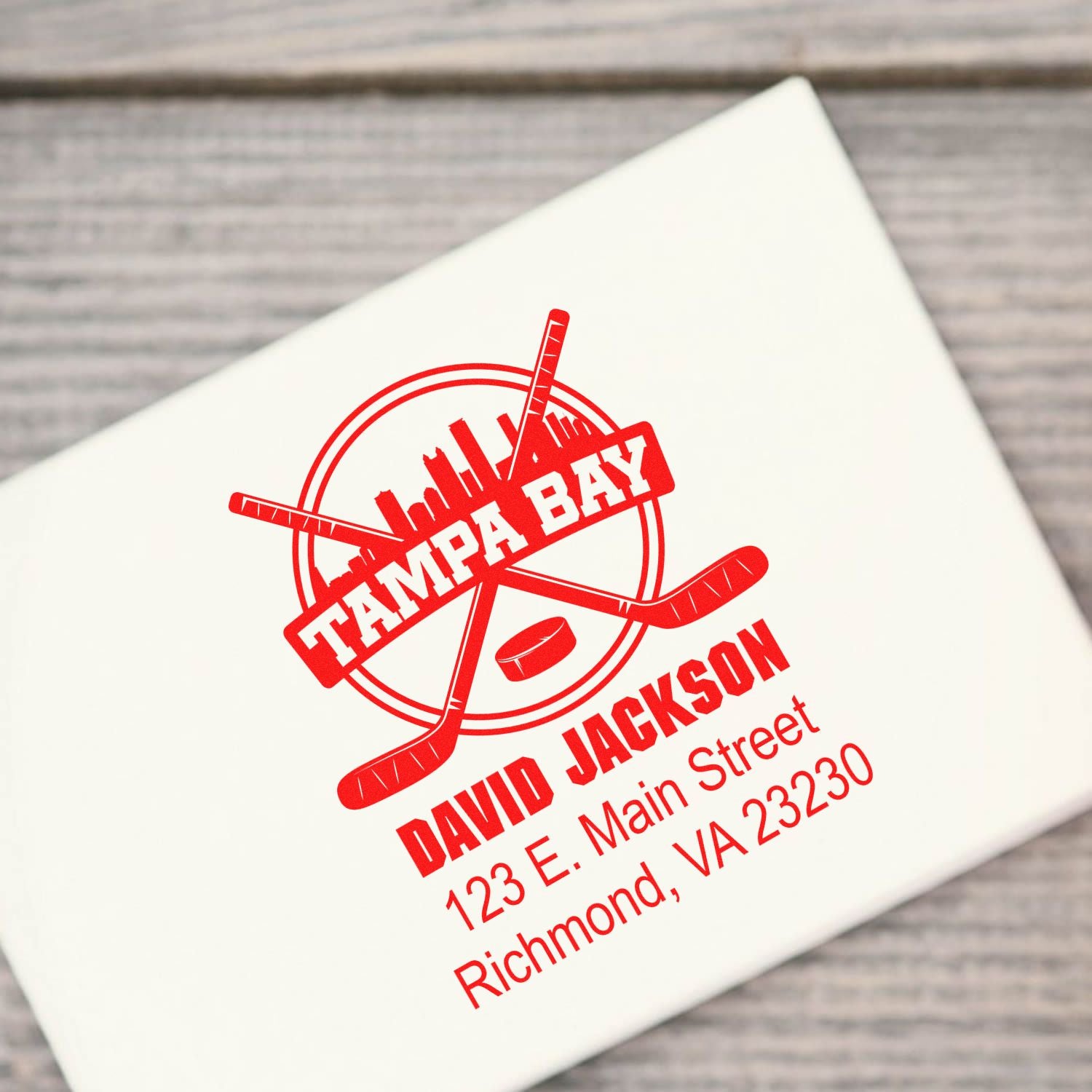 Custom Tampa Bay hockey rubber stamp with personalized name, address, and crossed sticks logo for business branding.