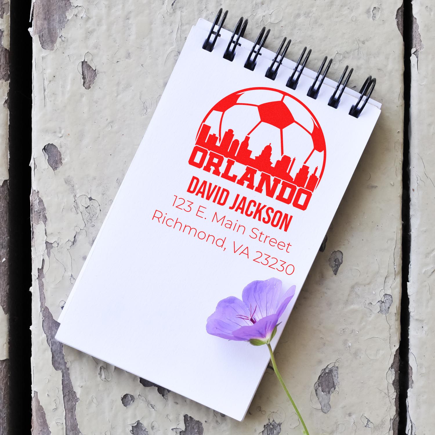 Custom Orlando address rubber stamp with logo, David Jackson name, and Richmond, VA details on a spiral notebook.