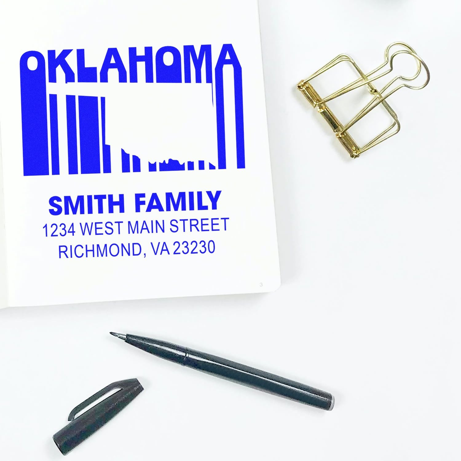 Custom Oklahoma skyline return address rubber stamp with Smith Family name and address, shown beside a pen and binder clip.