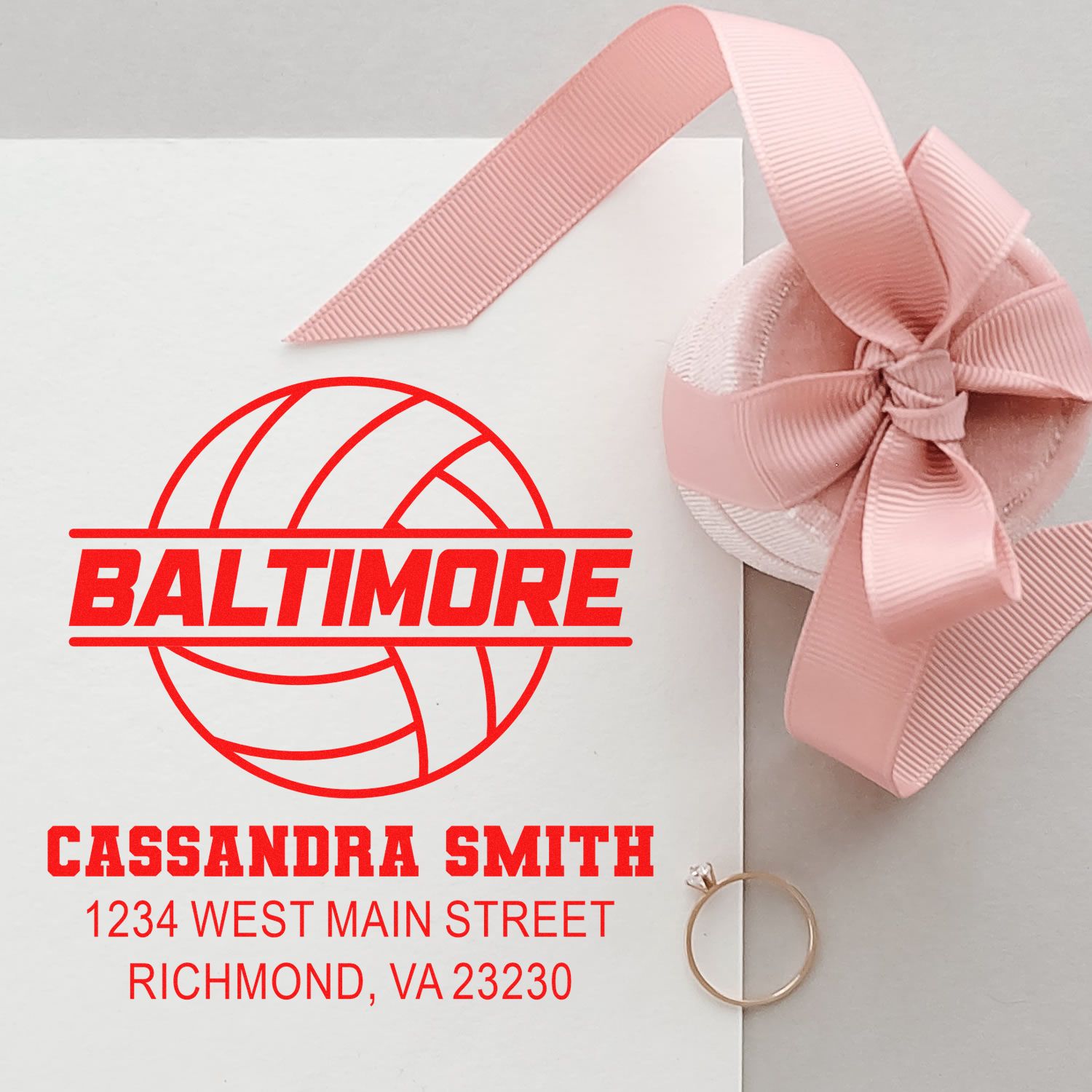 Custom rubber stamp for Baltimore branding on pink gift packaging with Cassandra Smith address.