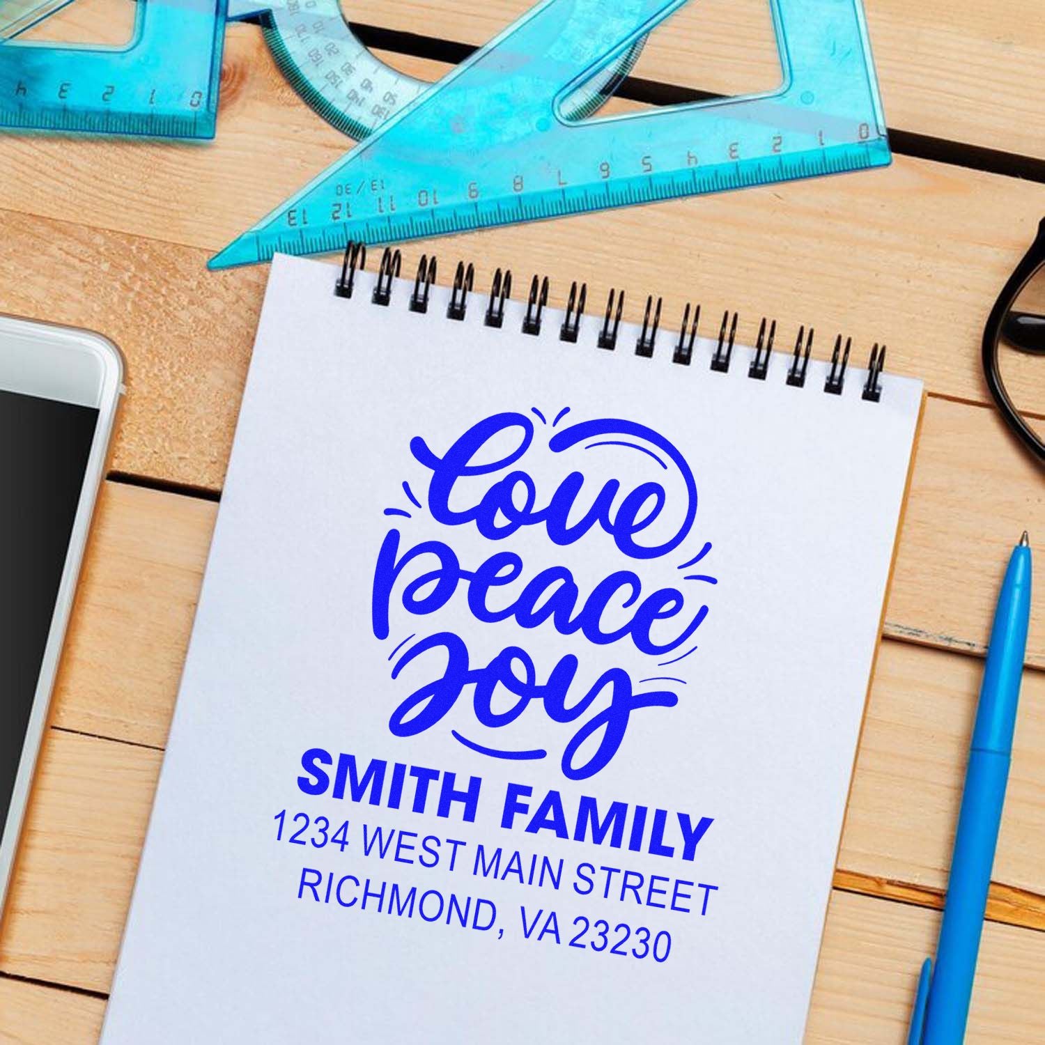 Personalized custom rubber stamp design with Love Peace Joy and Smith Family return address on a notepad.