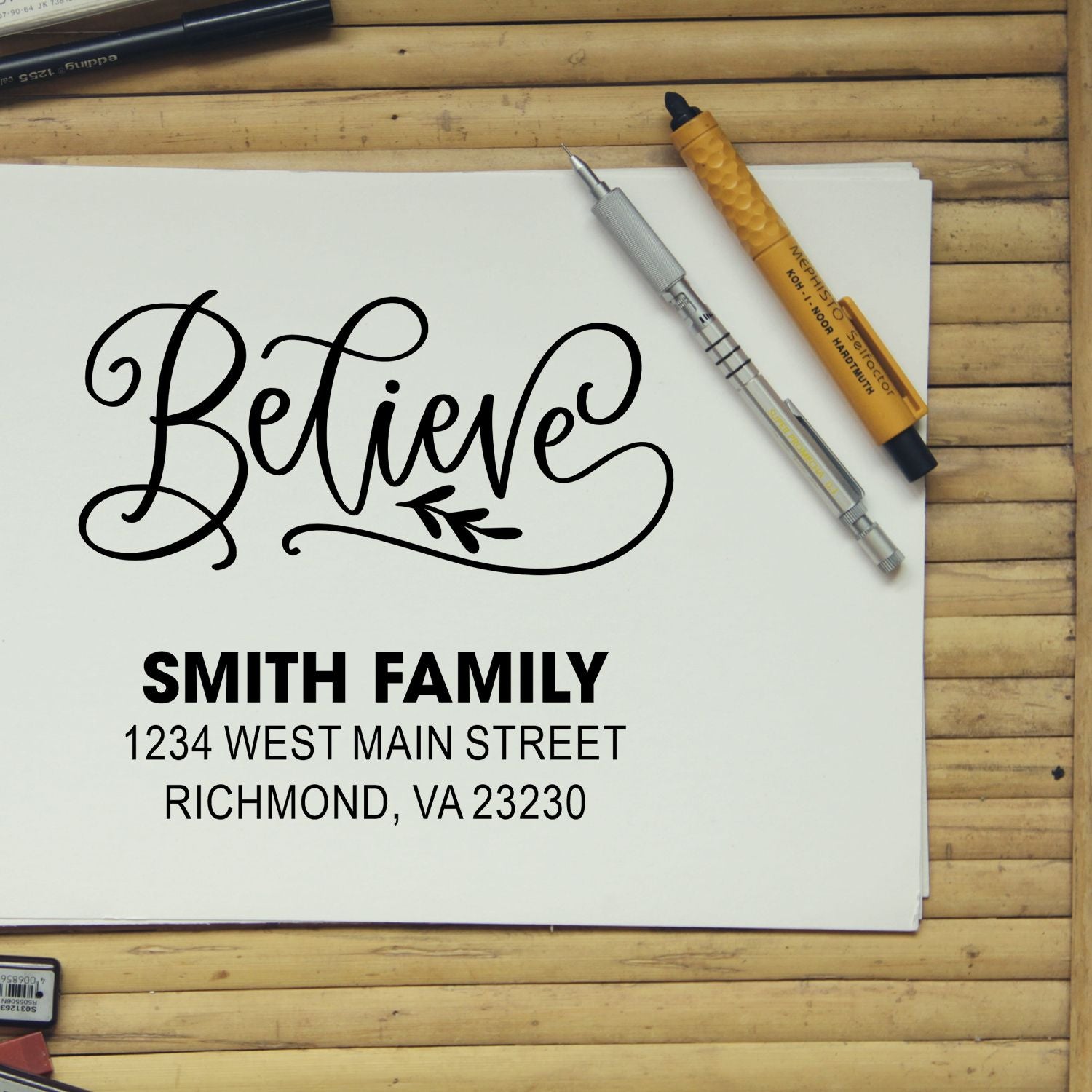 Custom rubber stamp mockup with Believe script and Smith Family return address for personalized stationery.