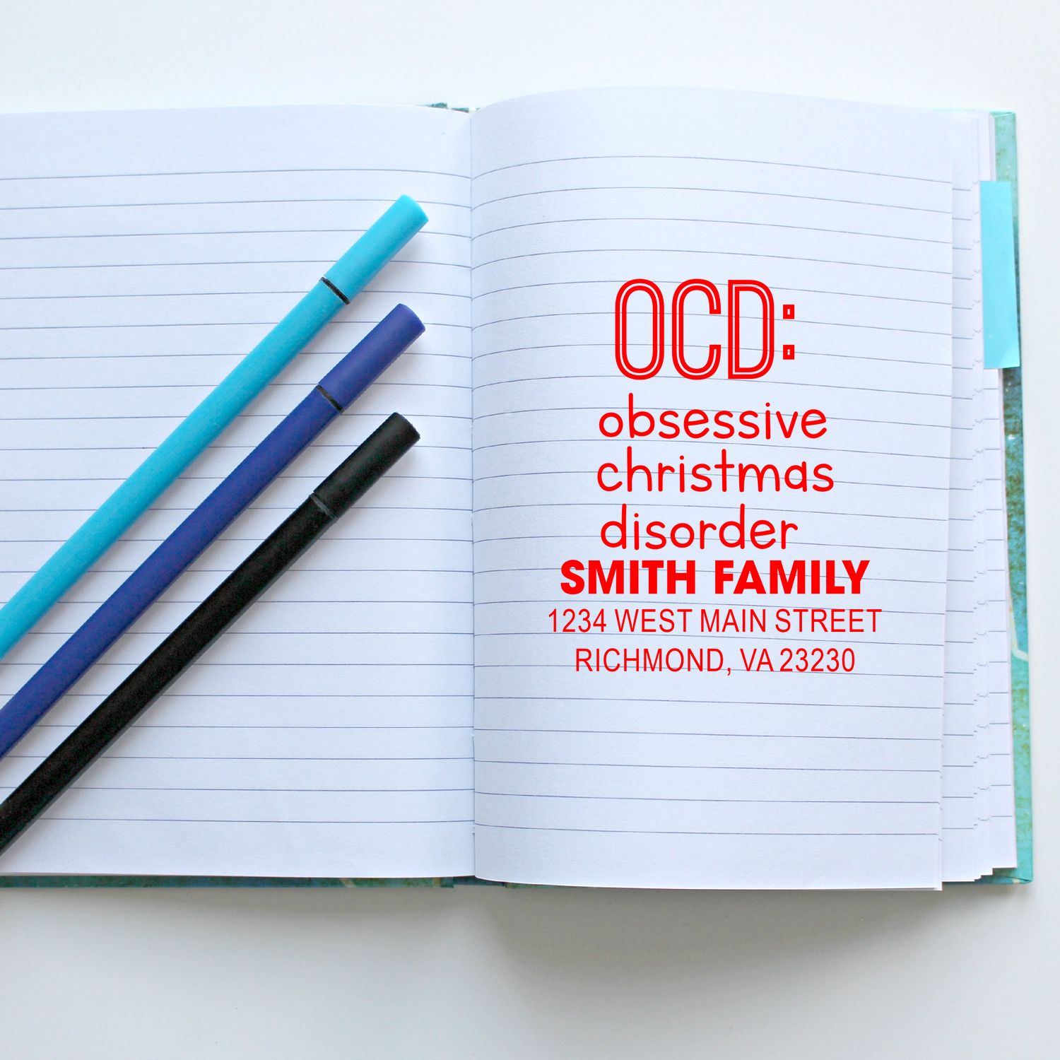 Custom rubber stamp design reading OCD: obsessive Christmas disorder with Smith Family address on notebook for holiday stationery.