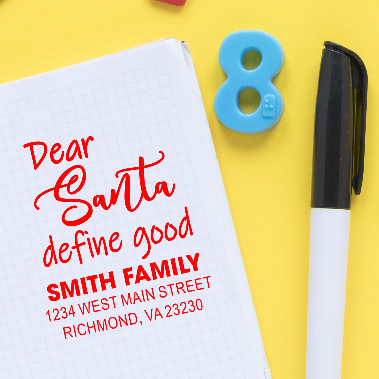 Custom rubber stamp impression with Dear Santa and Smith family address on a notebook.