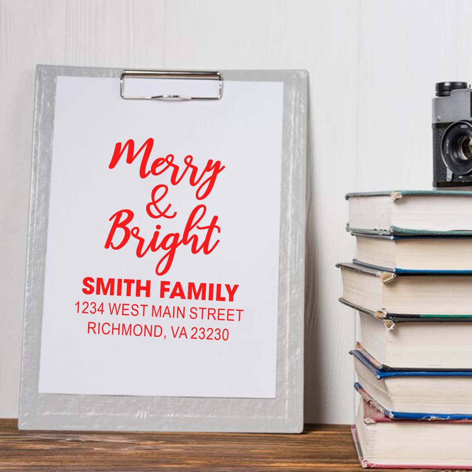 Custom Merry & Bright holiday address stamp for Smith Family, shown on a clipboard with festive Christmas card design.