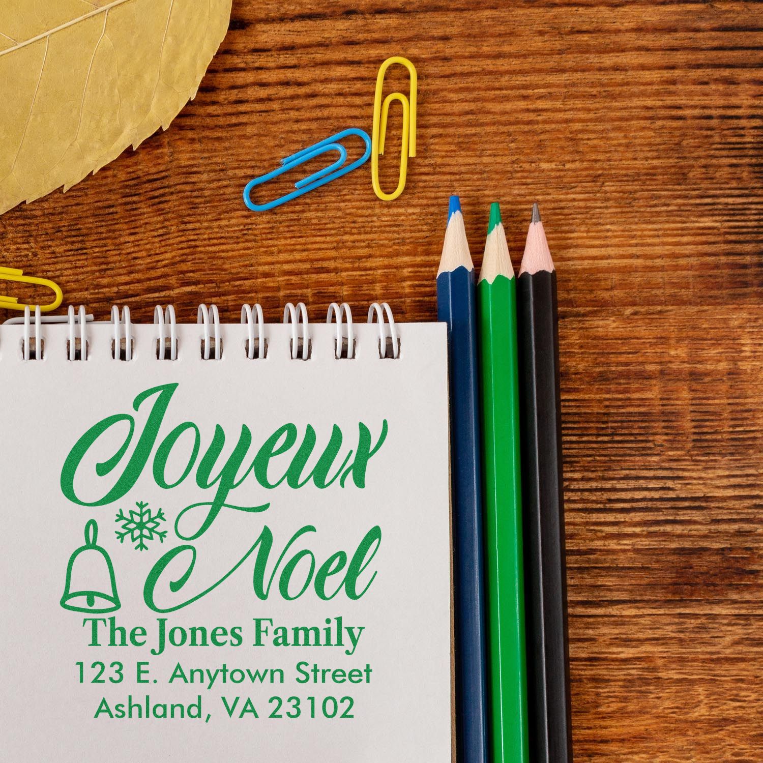 Custom Joyeux Noel rubber stamp design with family name and address for personalized Christmas cards.