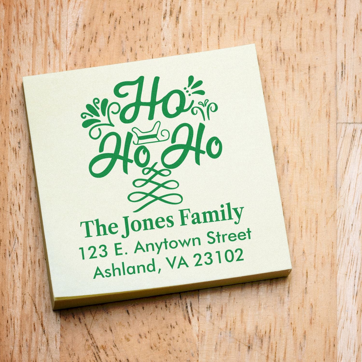 Personalized Ho Ho Ho holiday return address rubber stamp with family name and mailing address in green.