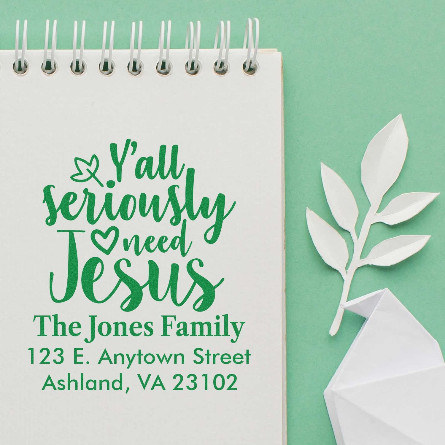 Personalized rubber stamp design with Yall seriously need Jesus, The Jones Family, and address in green on a notebook page.