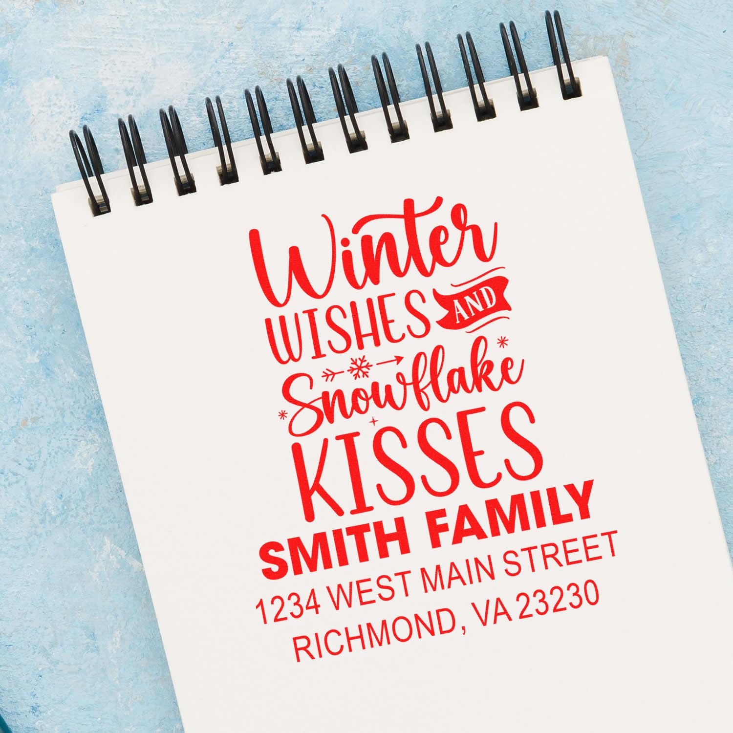 Custom winter wishes rubber stamp with snowflake kisses greeting, family name, and return address for holiday cards.