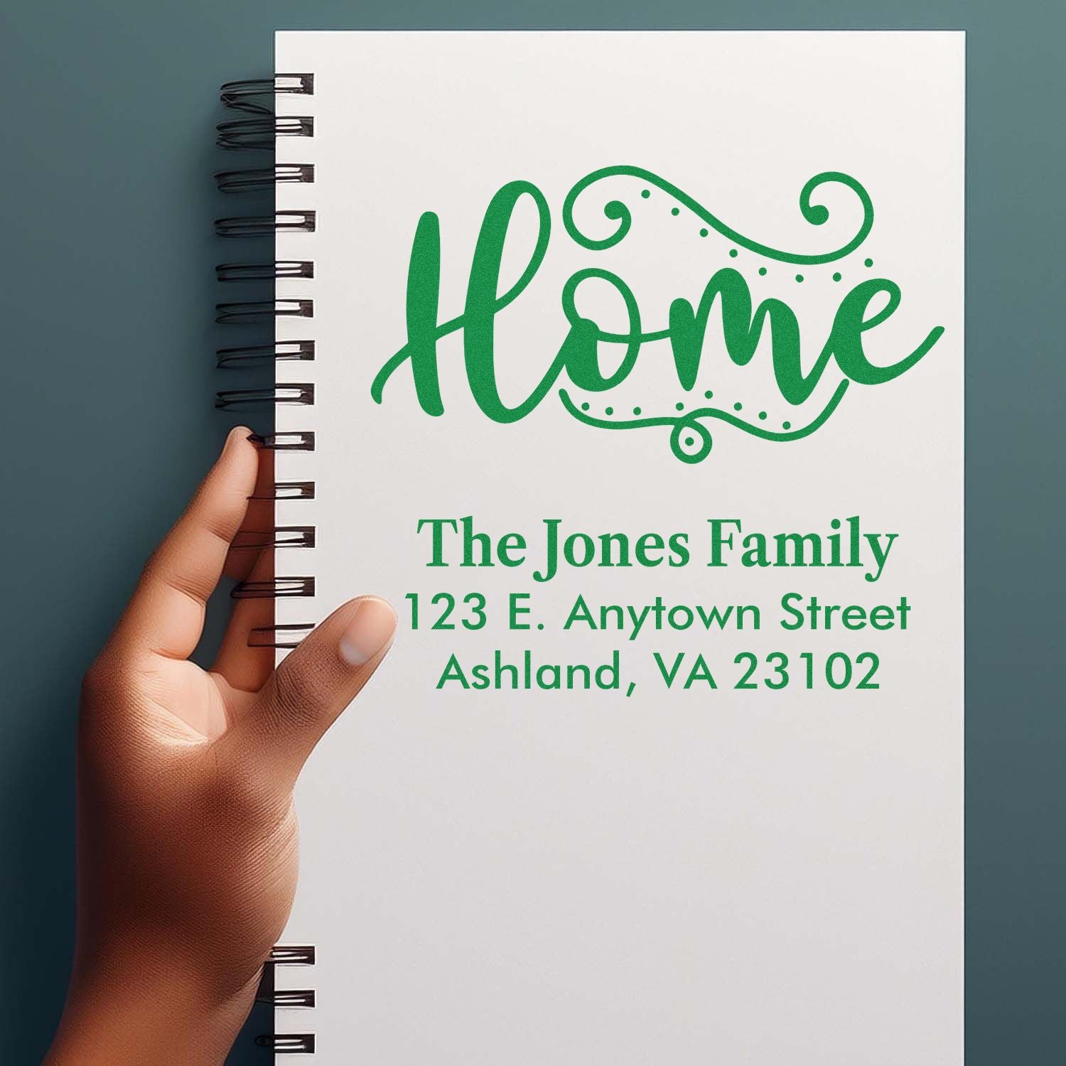 Custom home address rubber stamp design with personalized family name and address on a notebook cover.
