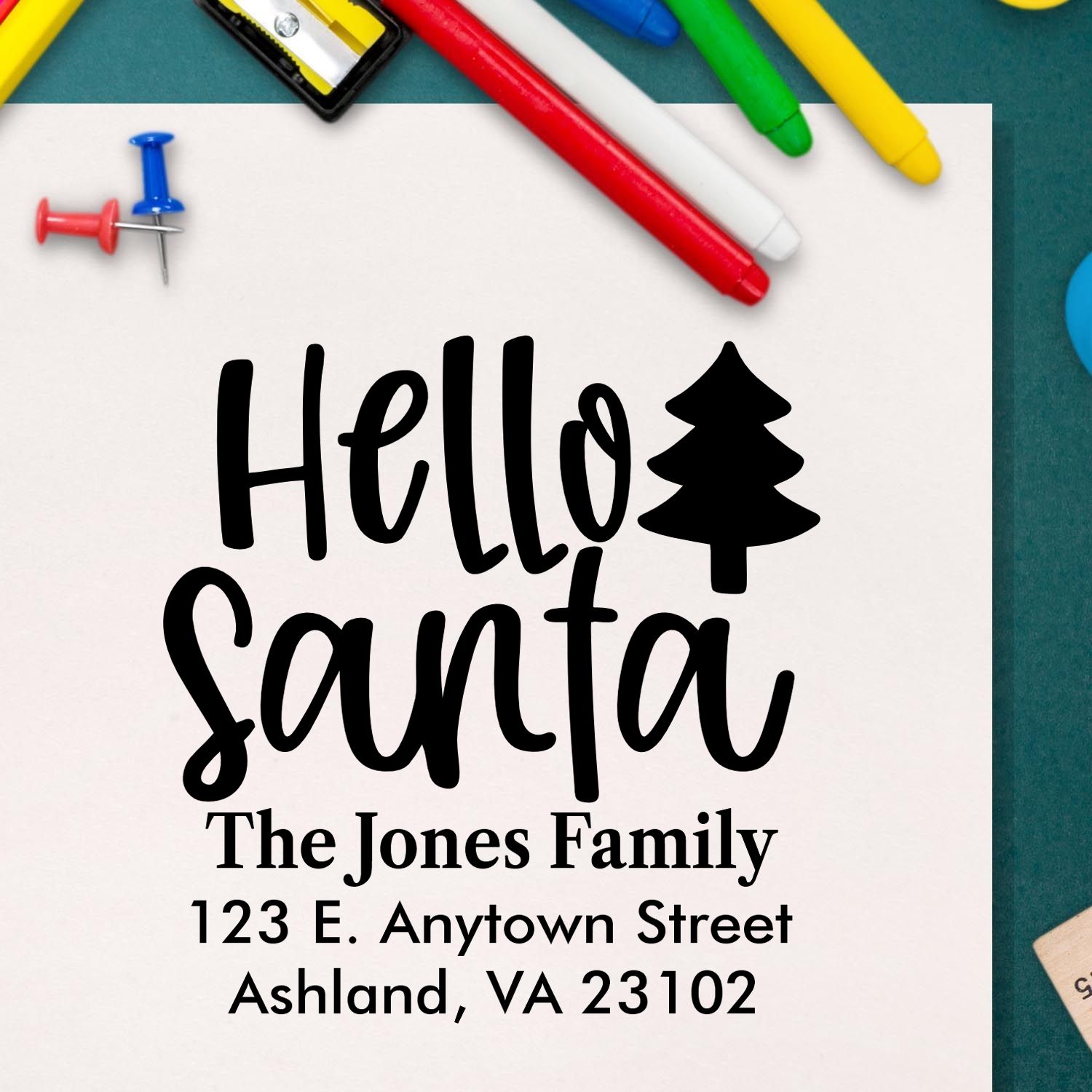Custom holiday rubber stamp with Hello Santa, Christmas tree icon, family name, and return address for festive mail.