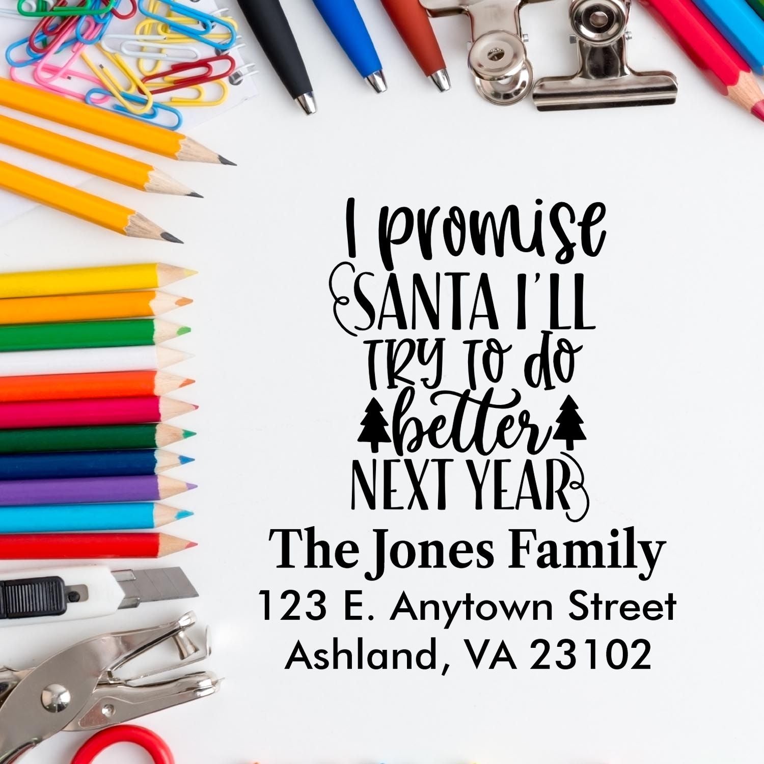 Custom rubber stamp mockup with pencils and clips, showing a holiday return address stamp that reads "I promise Santa I'll try to do better next year.