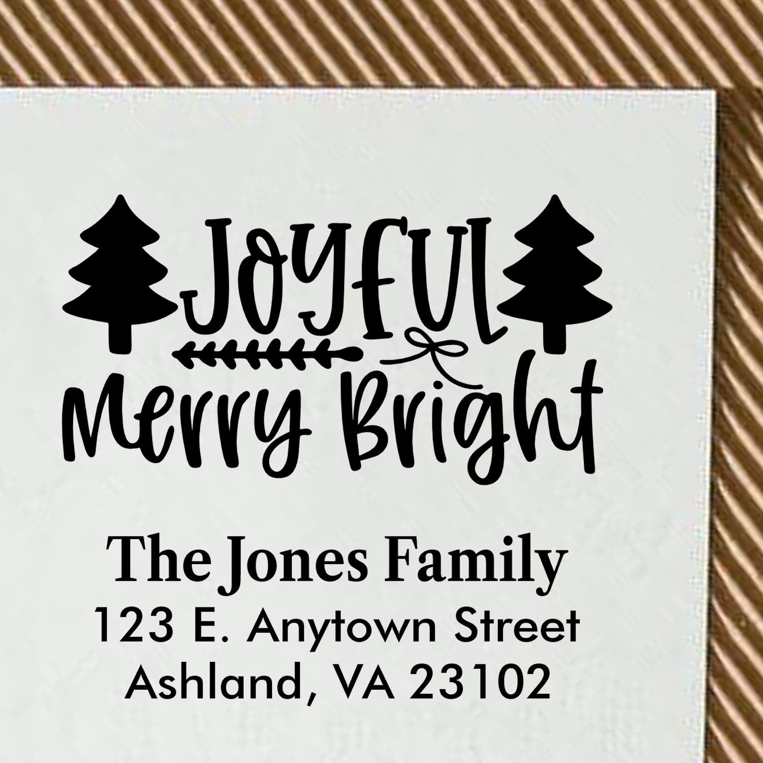 Christmas rubber stamp design with Joyful Merry Bright message, pine trees, and personalized family name and address.