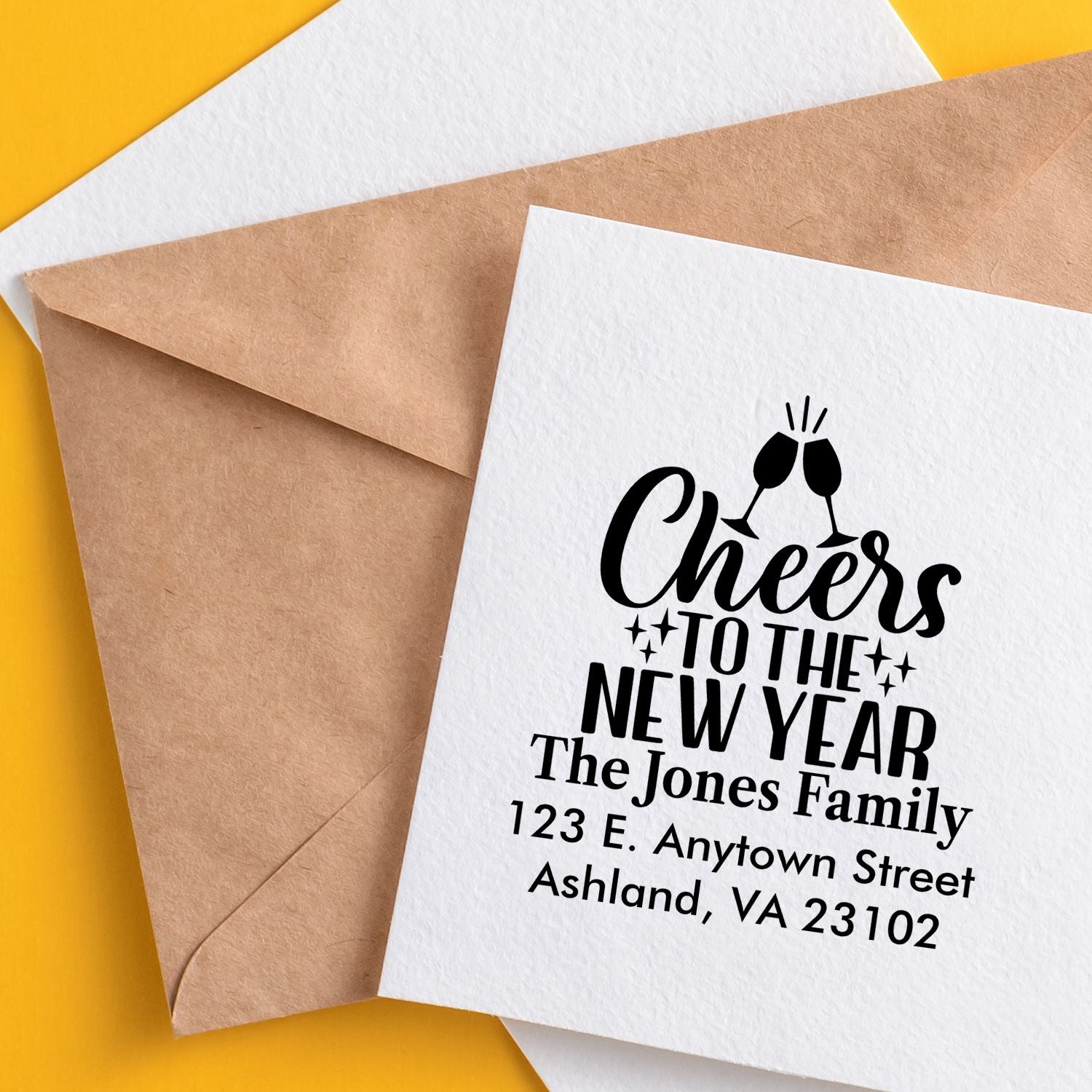 Custom rubber stamp for New Year cards with cheers message and personalized family return address on envelopes.