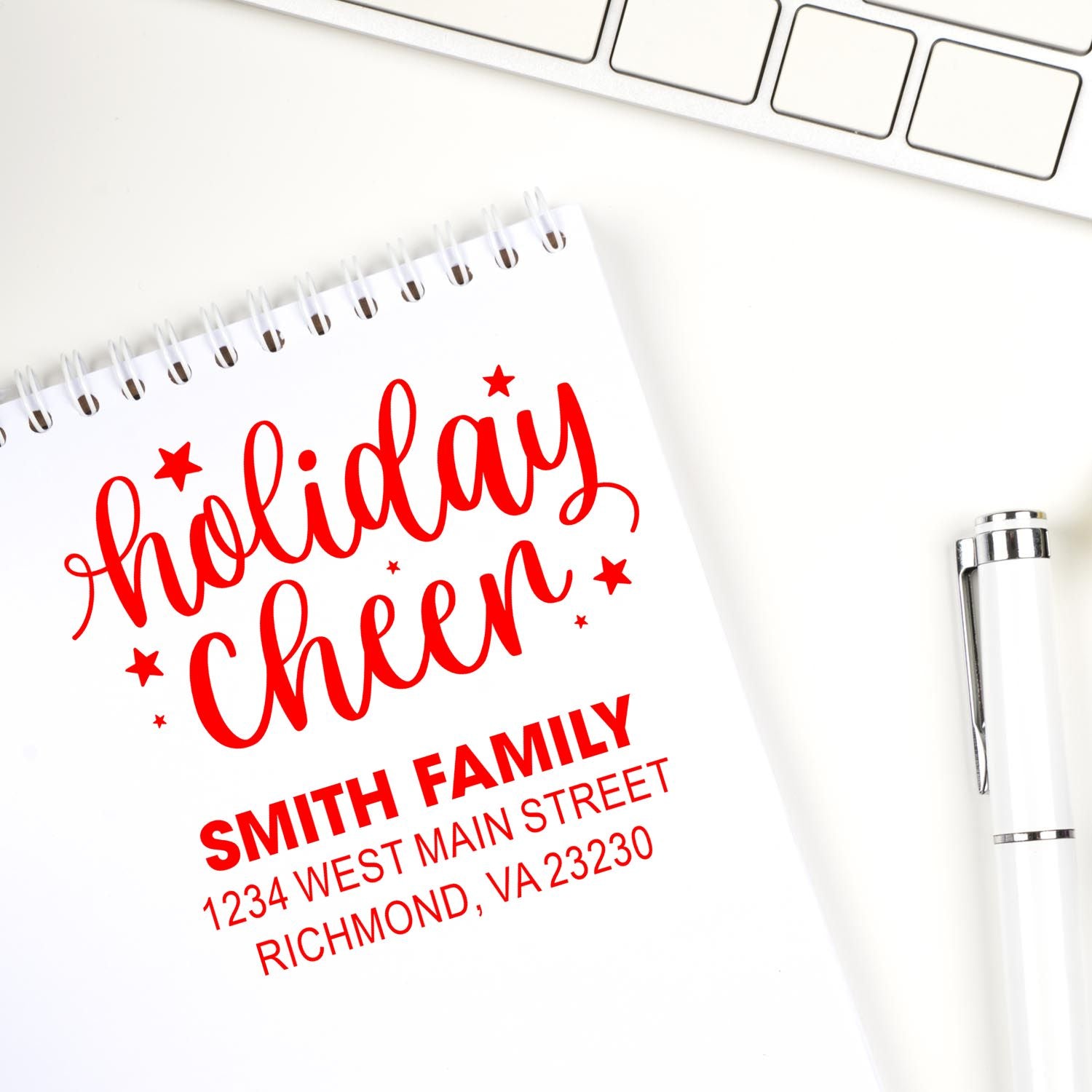 Custom holiday cheer return address rubber stamp for holiday cards, shown with Smith family address on notebook mockup.