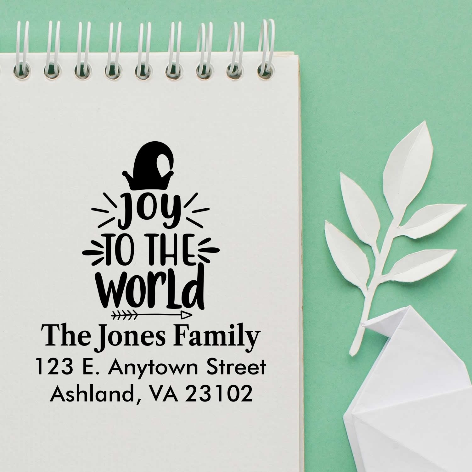 Custom holiday rubber stamp with Joy to the World design, family name, and return address for festive card and package labeling.