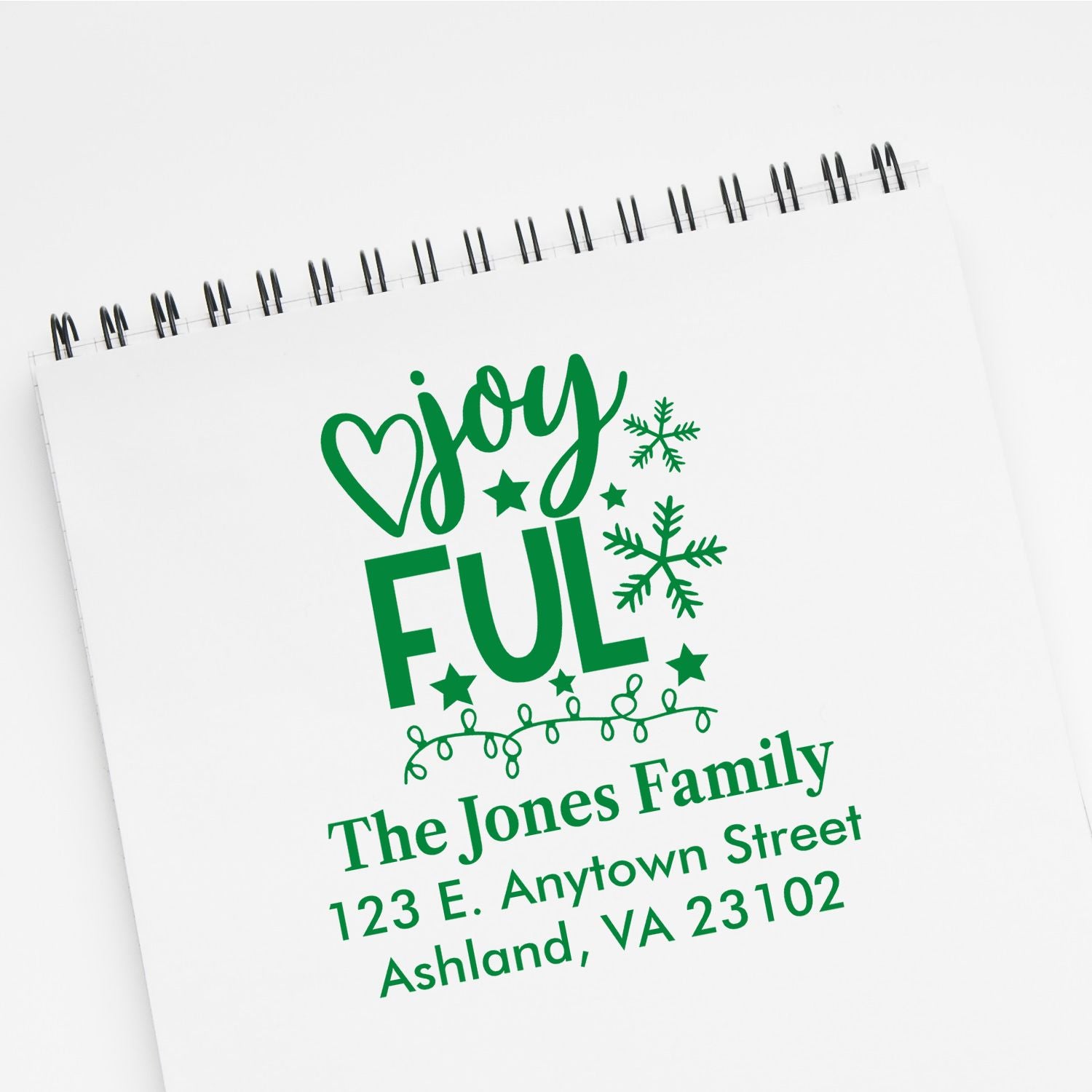 Custom Christmas return address rubber stamp mockup featuring Joyful design with family name, street address, and snowflakes.